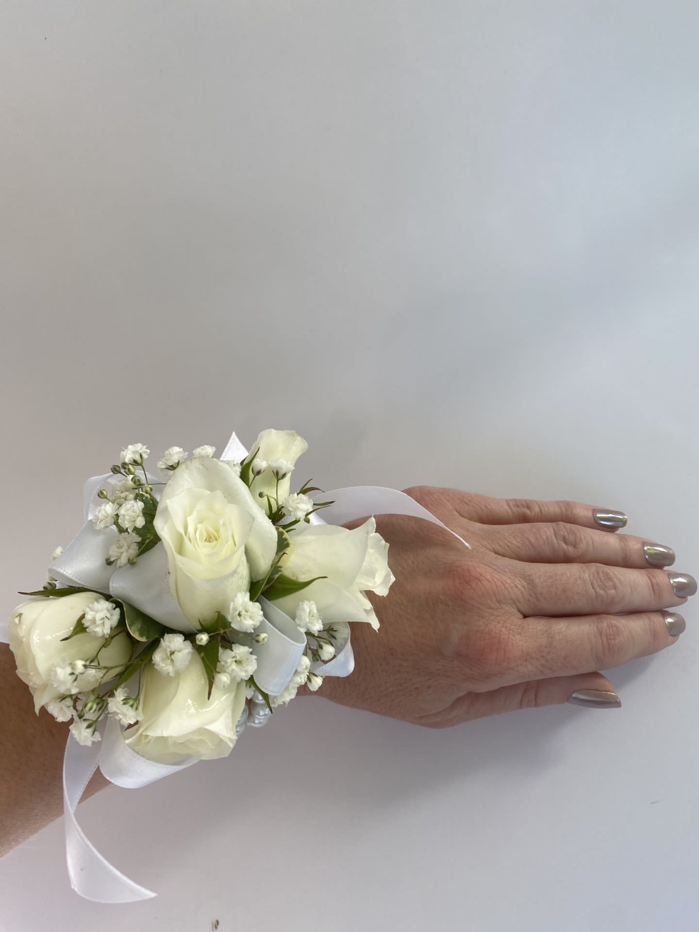 Corsage / Wrist - White Spray Roses - Complete your look and make your special night unforgettable with our Custom Wrist Corsage, a one-of-a-kind accessory designed to elevate any formal event. Handcrafted with the freshest flowers, each corsage is uniquely designed to complement your style and is ideal for proms, homecoming dances, weddings, and other celebrations. Whether your aesthetic is elegant, dramatic, feminine, or bold, we’ll bring your vision to life with exquisite attention to detail. -Key Features: **Fresh, Hand-Picked Florals: Crafted with the highest quality flowers, ensuring a vibrant and polished design. **Select Florals: We offer spray roses with natural accents, plus fully customizable corsages using various flowers, colors, and embellishments that perfectly complement your attire and event's theme. **Comfortable Wear: Designed with a secure and stylish pearl tone band to ensure all-night comfort and ease of wear. **Upgrade for Versatile Styles: From minimal and elegant to bold and dramatic, our corsages can be tailored to fit any personal aesthetic. CALL US for upgrades. Let your wrist corsage be more than just an accessory—make it a statement. Order today and let us create a custom design that perfectly complements your style and makes your evening unforgettable!