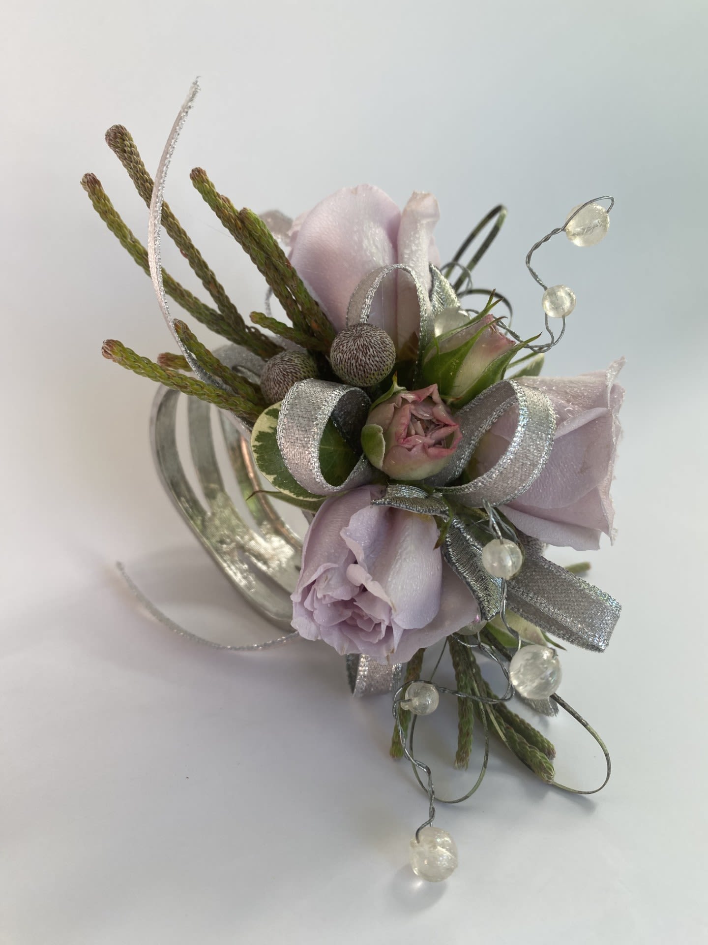 Corsage / Wrist - Custom Spray Rose - Custom Spray Rose Bracelet Corsage Make your special night truly unforgettable with our Custom Spray Rose Bracelet Corsage, a handcrafted masterpiece designed to elevate any formal occasion. Featuring fresh spray roses, natural foliage accents, and luxurious details, this one-of-a-kind corsage is perfect for proms, homecoming dances, weddings, and other cherished celebrations. Whether your aesthetic is elegant, feminine, dramatic, or bold, we’ll bring your vision to life with exceptional care and artistry. -Key Features: **Fresh Spray Roses: Delicate and vibrant blooms that add timeless beauty to your ensemble. **Natural Foliage Accents: Lush greenery enhances the organic and elegant design. **Exquisite Details: Pearl or rhinestone trims and specialty ribbons bring a touch of luxury and sophistication. **Comfortable Metal Bracelet: Adjustable and secure, designed for all-night wear without compromising on style. **Fully Customizable: Tailored to your preferences, including ribbon colors, floral upgrades, and other personal touches. -How to Order: To create your perfect corsage, please include the following details in your order notes: Dress color, Preferred ribbon color, and/or Floral requests or favorite blooms (for upgrade quotes).