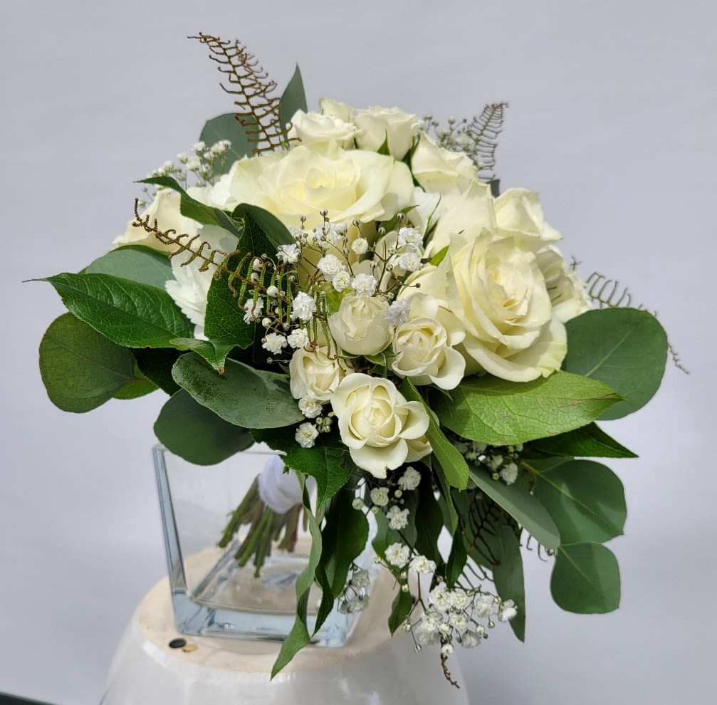 Nosegay in Whites - A Timeless Classic for Life’s Most Memorable Moments Celebrate elegance and sophistication with our Nosegay in Whites, a hand-held bouquet designed to complement the most cherished occasions. Perfect for proms, homecoming dances, recitals, and weddings, this bouquet exudes timeless beauty and grace. ***Luxurious Composition: Featuring a lush base of white hydrangea, accented with open premium roses, garden roses, and tiny spray roses, this arrangement is a harmonious blend of texture and depth. ***Delicate Details: Filler accents and natural greenery add an organic touch, creating a bouquet that feels both refined and nature-inspired. ***Versatile Elegance: Elegantly bound in white ribbon, this bouquet complements semi-formal and formal wear, from tea-length dresses and bridal gowns to evening wear. Each bouquet is meticulously hand-designed to ensure freshness and quality, making it a perfect choice for creating unforgettable memories.