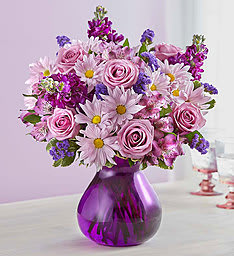 Lavender Dreams - Here’s a truly original arrangement only we could have dreamed up! Filled with the freshest roses, daisy poms and more in lovely shades of purple, it’s hand-designed inside a stylish purple glass vase to bring out the richness of its color— and the thoughtfulness of your sentiment.