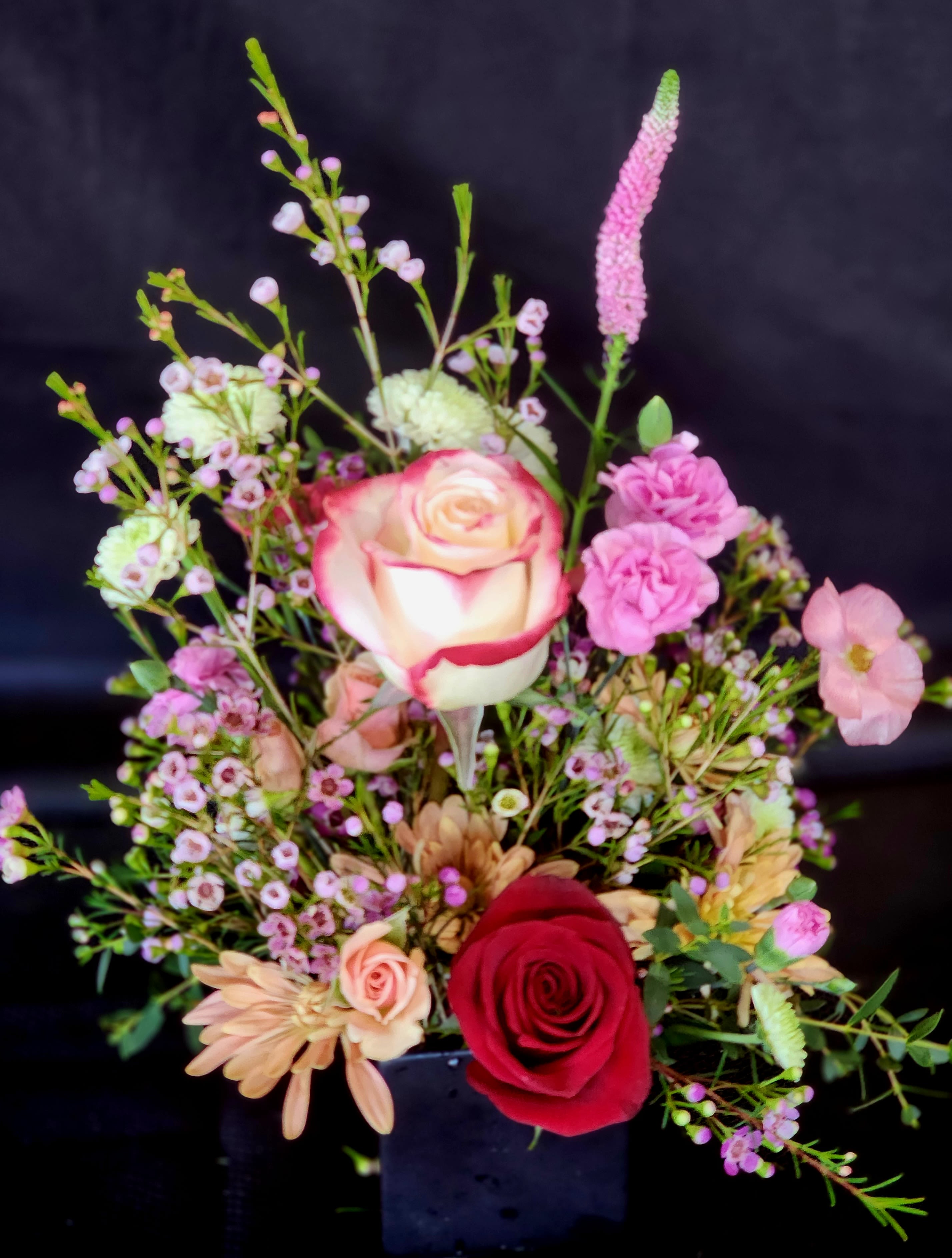 Itty Bitty - Petite arrangement in a black or white ceramic container - 3 1/2" x 3 1/2". Perfect for a bedside table or in dorms. Deluxe is 5" x 5" Please specify rose color on the note section if you have a preference.