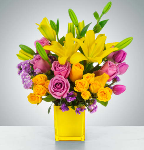 Sunday Afternoon - This arrangement is a sweet surprise for any recipient. Featuring a selection of yellow and purple flowers in a yellow vase, this arrangement is springtime in flower form and a great gift for Easter or Passover.  