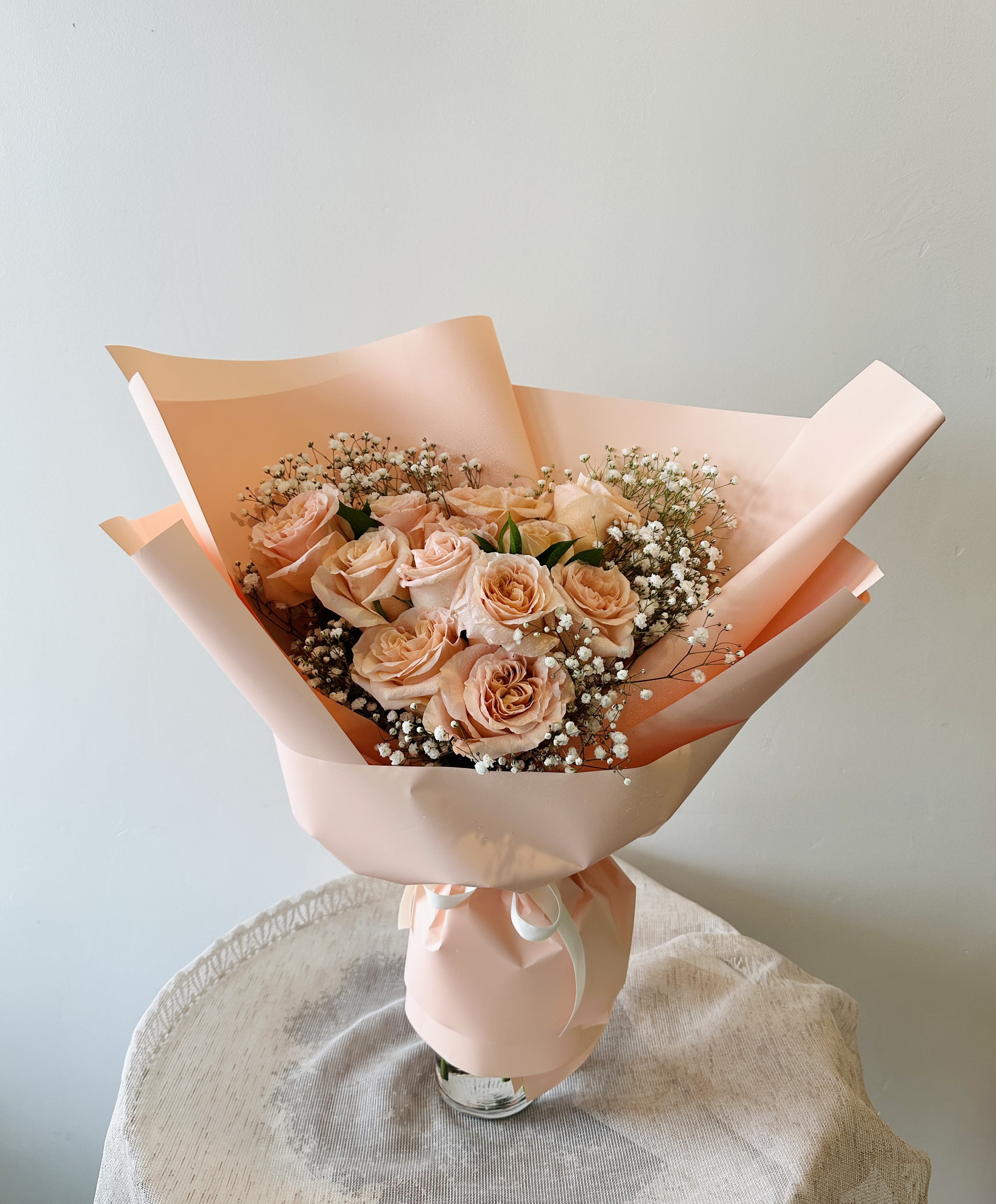 1 Dozen Peach Rose Hand Bouquet (Vase not included) - Surprise your loved one with our beautiful handcrafted bouquet consisting of a dozen delicate peach roses, carefully arranged by Flower Talk's skilled florists.   Standard: 12 roses Deluxe: 18 roses Premium: 24 roses