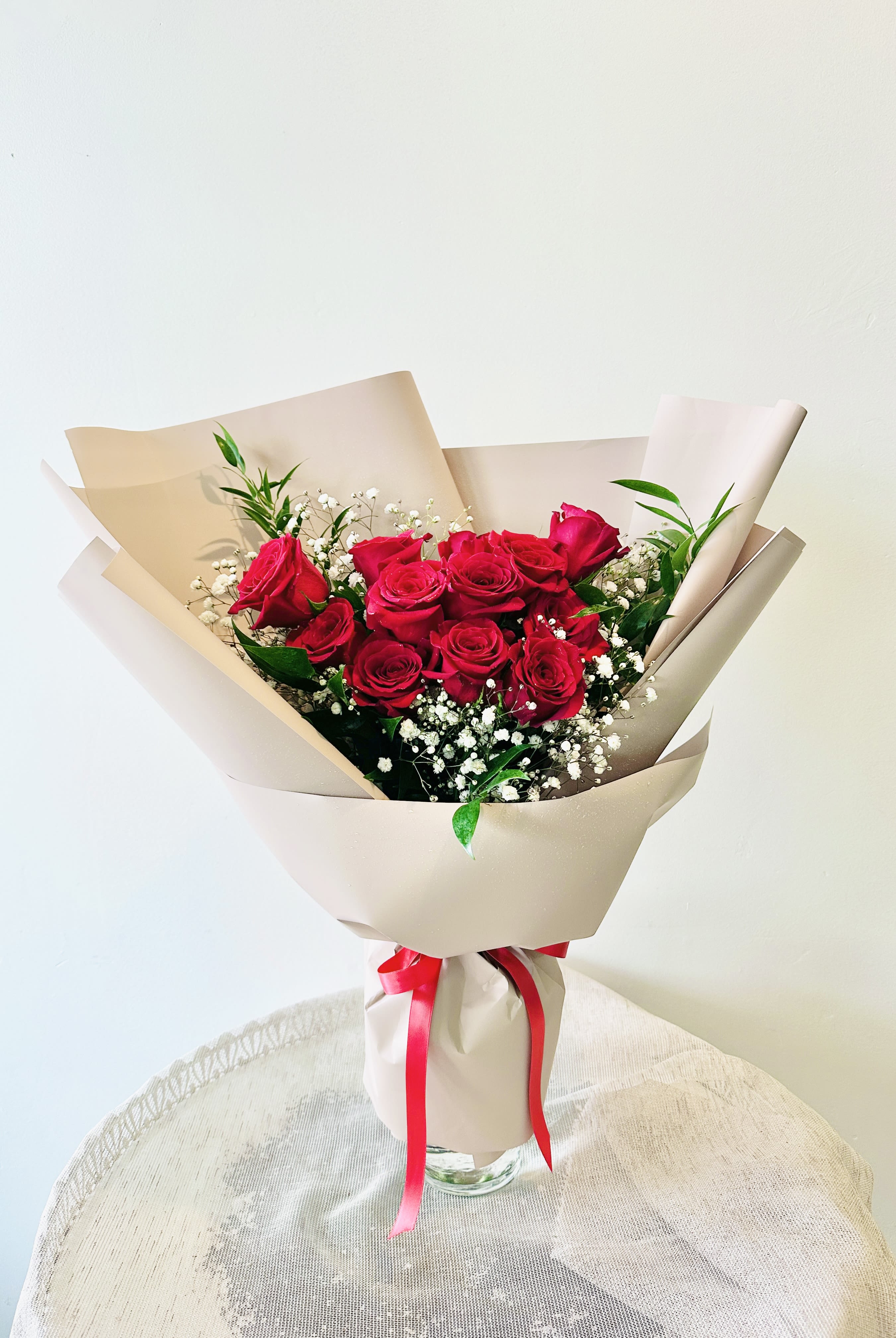 Rosa Hand Bouquet (Vase not included) - Dozen red roses tied in a hand bouquet This bouquet does not come with the vase.  Standard: 12 roses Deluxe: 18 roses Premium: 24 roses