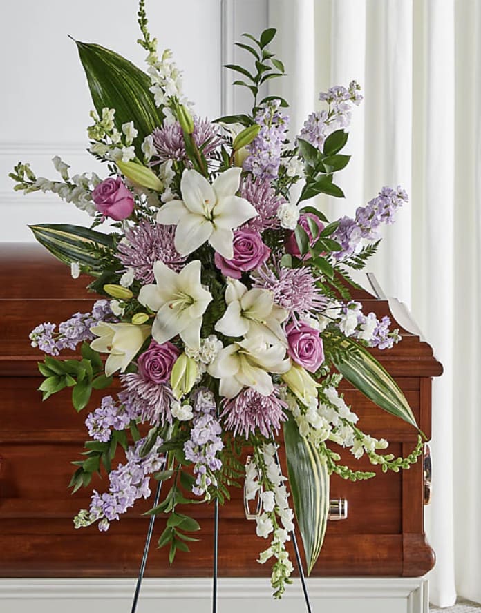In Our Prayers - Convey heartfelt condolences with this elegant standing spray, featuring a soothing array of lavender and white flowers. Details Standard Spray is approximately 35"H x 21"W. Designed by florists, ready to display. Pet Safety Precautions: This bouquet or plant may include flowers and foliage that are known to be toxic to pets. To keep them safe, be sure to keep this arrangement out of your pet's reach. Bloom Details Snapdragon Lily Stock Rose