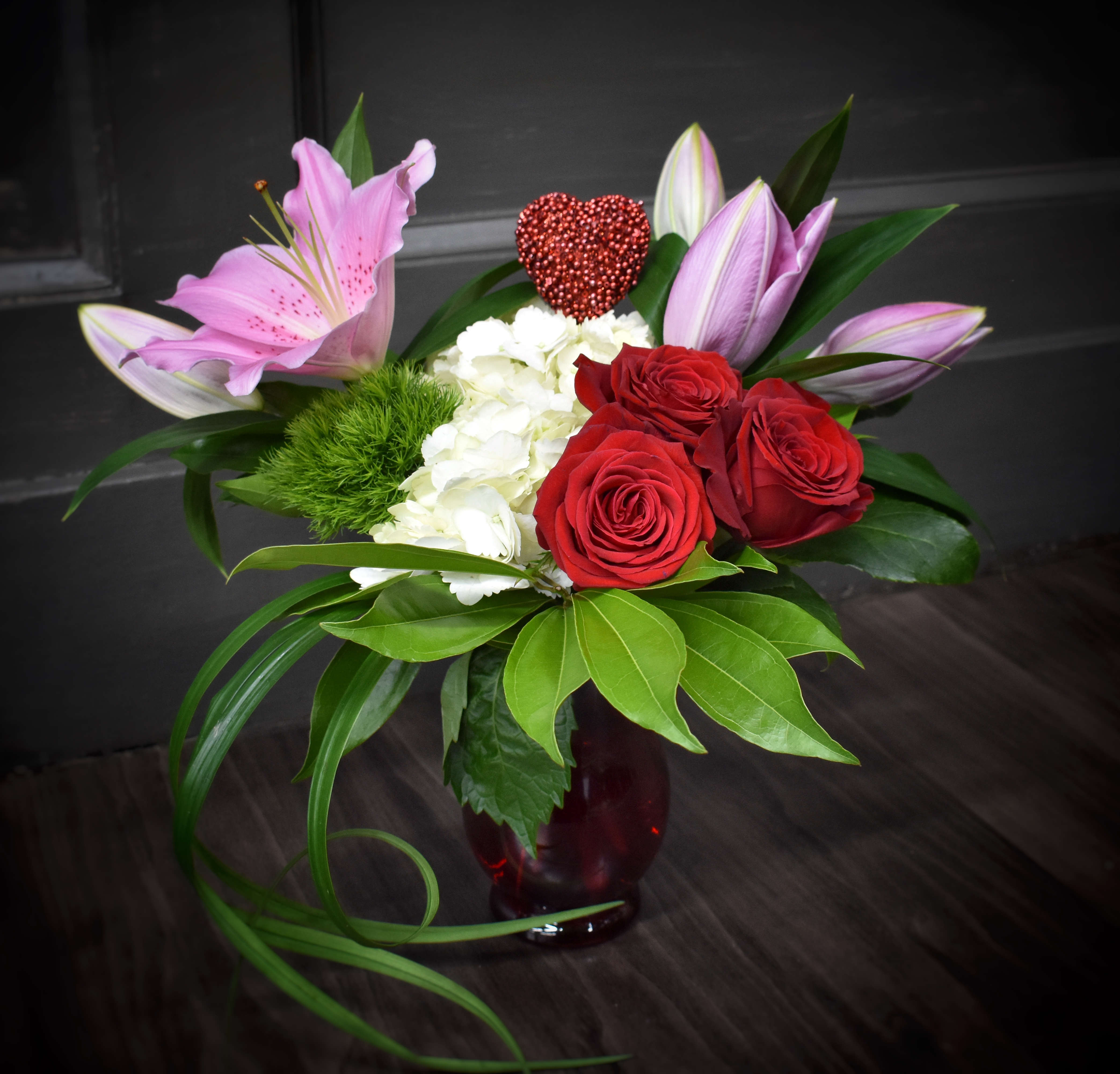  Be Mine Deluxe - This is the Deluxe version of Baby Be Mine- An embossed ceramic red containers with hydrangea, roses, foliages  and 2 stems of fragrant lilies.