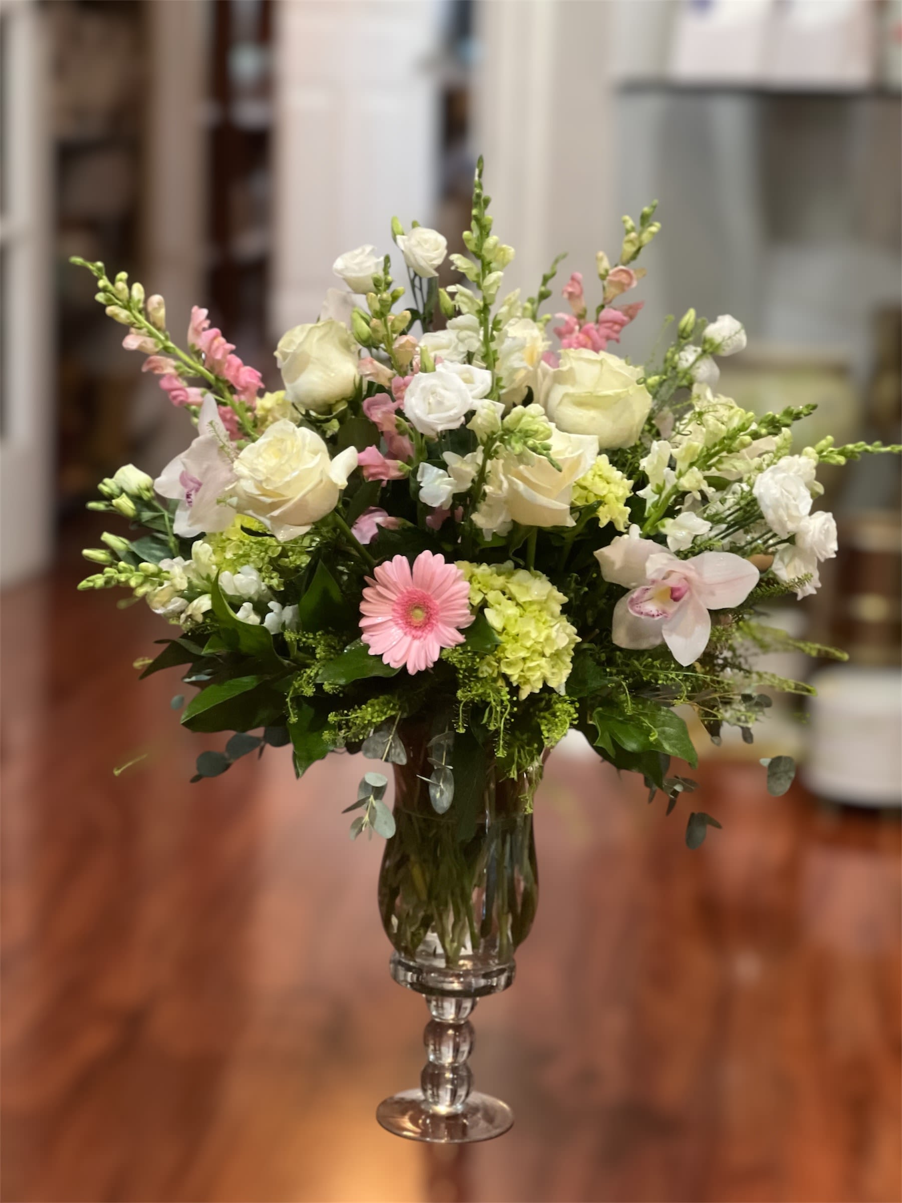 Sweetheart Twist - Indulge them with the allure of soft white roses, pink gerberas, cymbidium orchids, and vibrant greens, beautifully nestled in our glass vase for an unforgettable gesture.