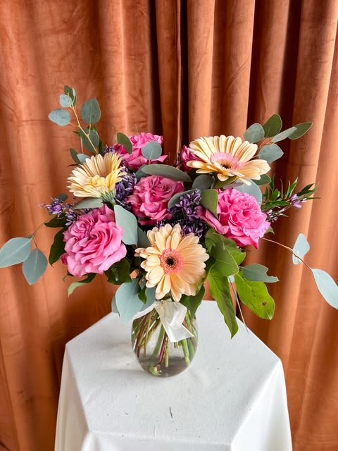 Gerbera Daisy + Roses - This bouquet brings together the gentle beauty of gerbera daisies and garden roses, thoughtfully arranged with seasonal accents for a fresh, natural feel. A meaningful choice for honoring special moments, expressing sympathy, or sharing heartfelt sentiments. *Exact flower varieties and colors may vary based on availability, while maintaining the overall style and value.