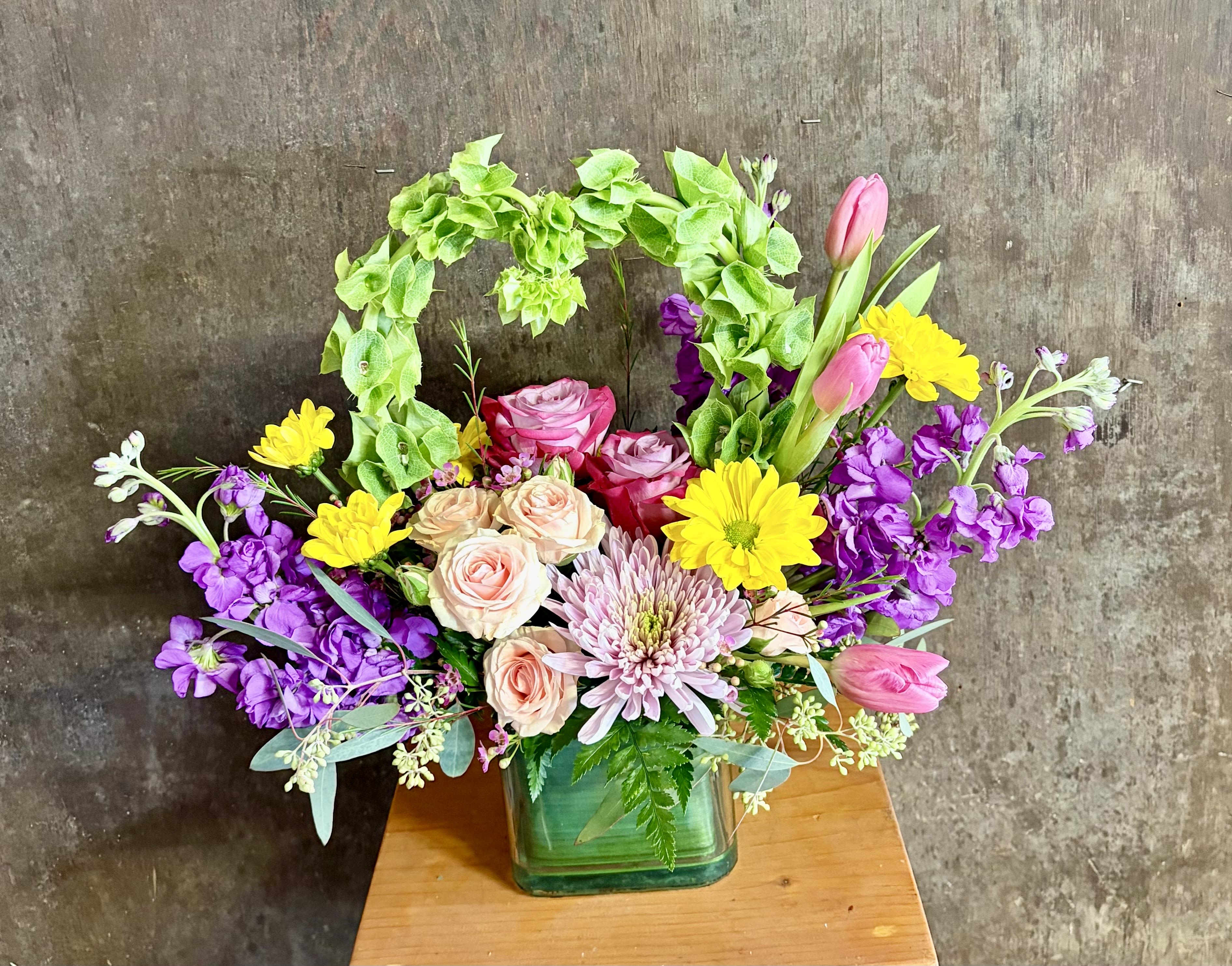 Garden of Love - A mixture of colorful spring blooms in a glass vase. Flowers and color may vary, but style will be the same.