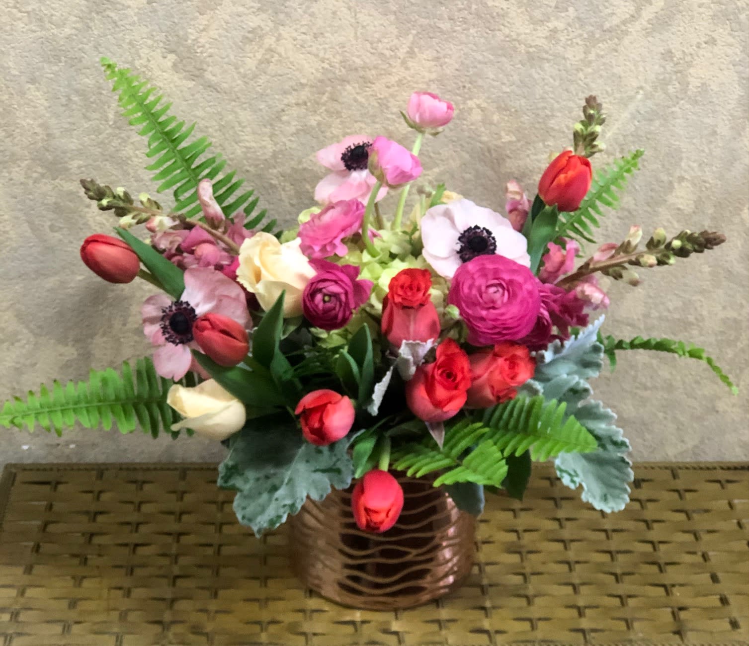 Rose Gold - Type of Flowers: Roses, Seasonal Ranunculus, Tulips, Seasonal Anemones, Snapdragons, Hydrangea and greens in a rose gold vase. Seasonal: Winter (Nov-March), end of Summer- (August)  Design View: All Facing View Photos available: Standard, Deluxe