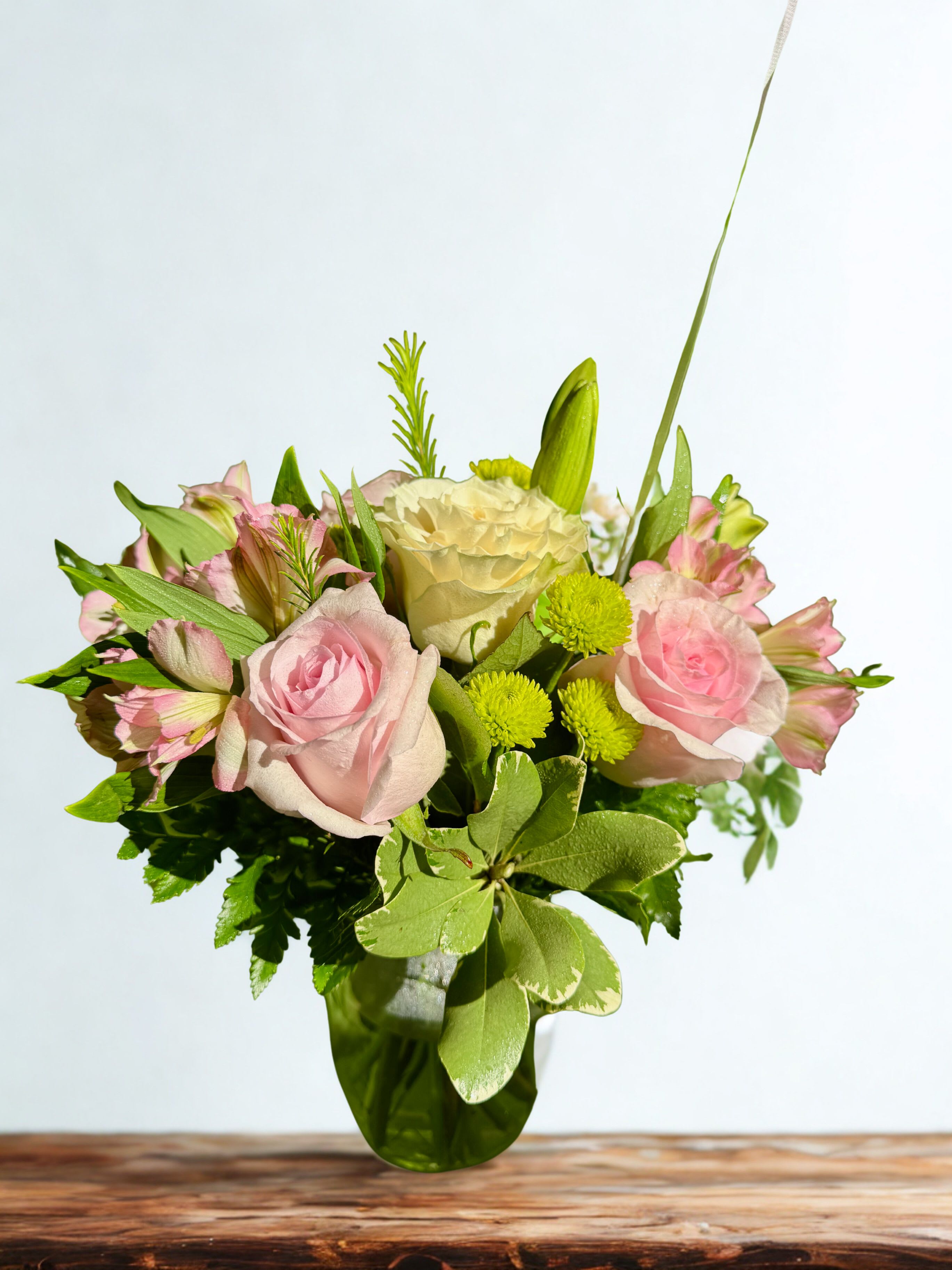 Endless Romance Bouquet - This soft colored bouquet will make a statement of gentle love. Our stunning bouquet of white, pink roses with light pink alstromeria, green poms and pretty pitta negra. This arrangement is delivered in a glass vase that will forever remind her of your love. Enhance the surprise by adding a balloon, teddy bear, or chocolates for an extra-special touch. 