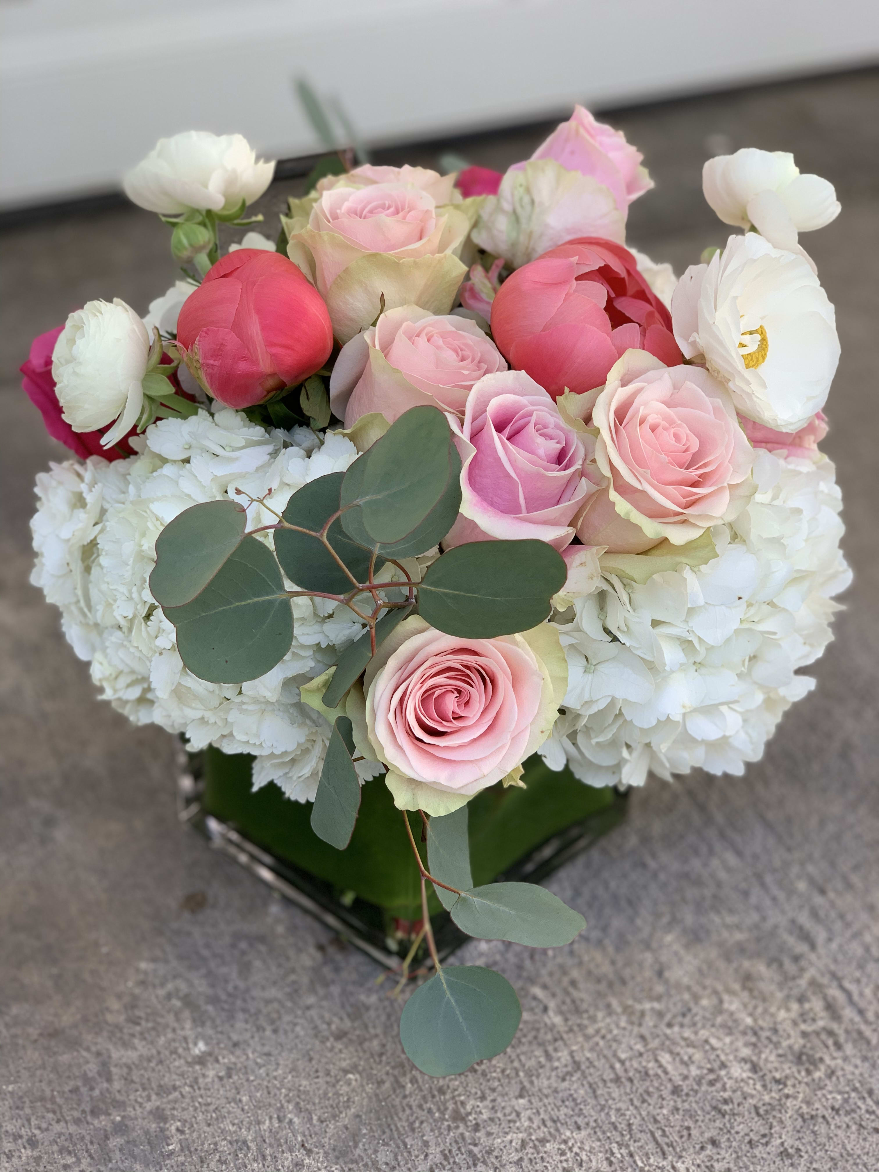Joyce - A rectangular glass vase filled with hydrangeas, roses, ranunculus, peonies and touch of eucalyptus.