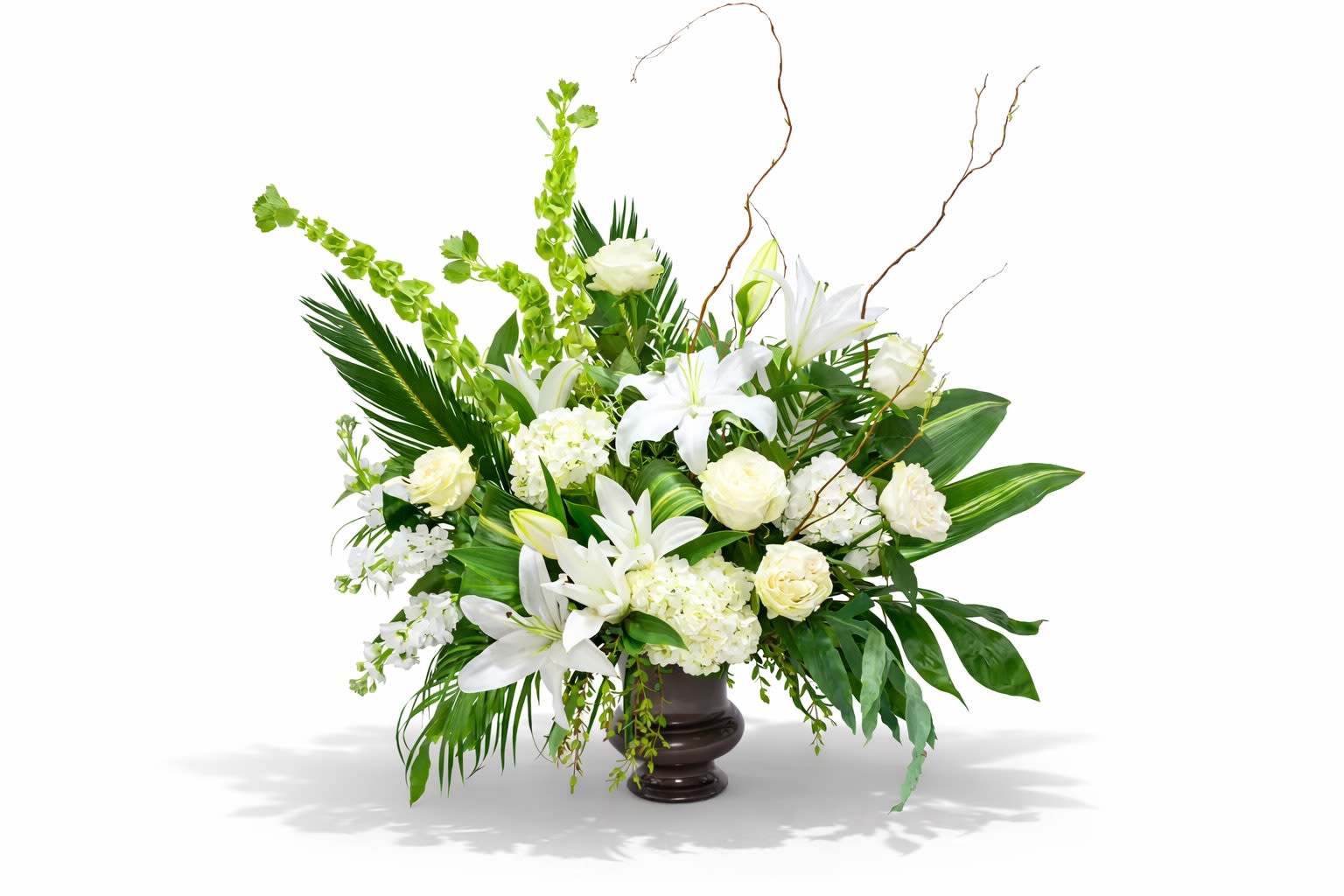 Peace &amp; Comfort - A forward facing urn arrangement of premium white and green seasonal blooms.  This design style is showy, so that all of the flowers are visible from the front to stand out at your loved one's service.