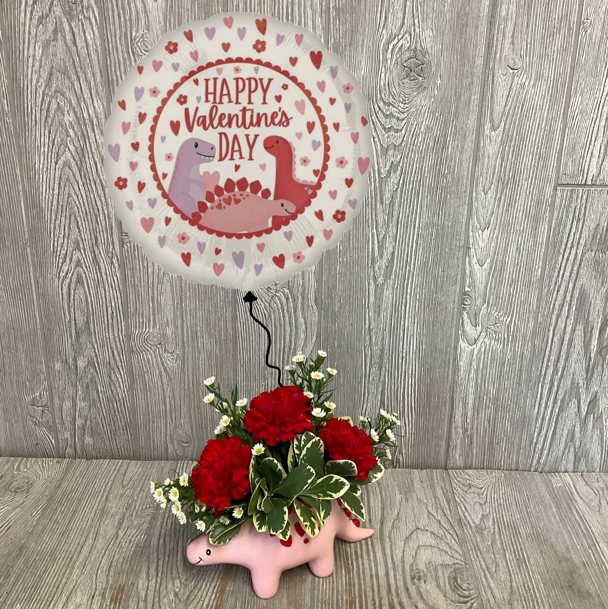 Valentine’s Dino Bundle - Surprise your Valentine with this sweet stegosaurus arrangement, coupled with a matching helium filled mylar balloon. Colors and flowers may vary. 