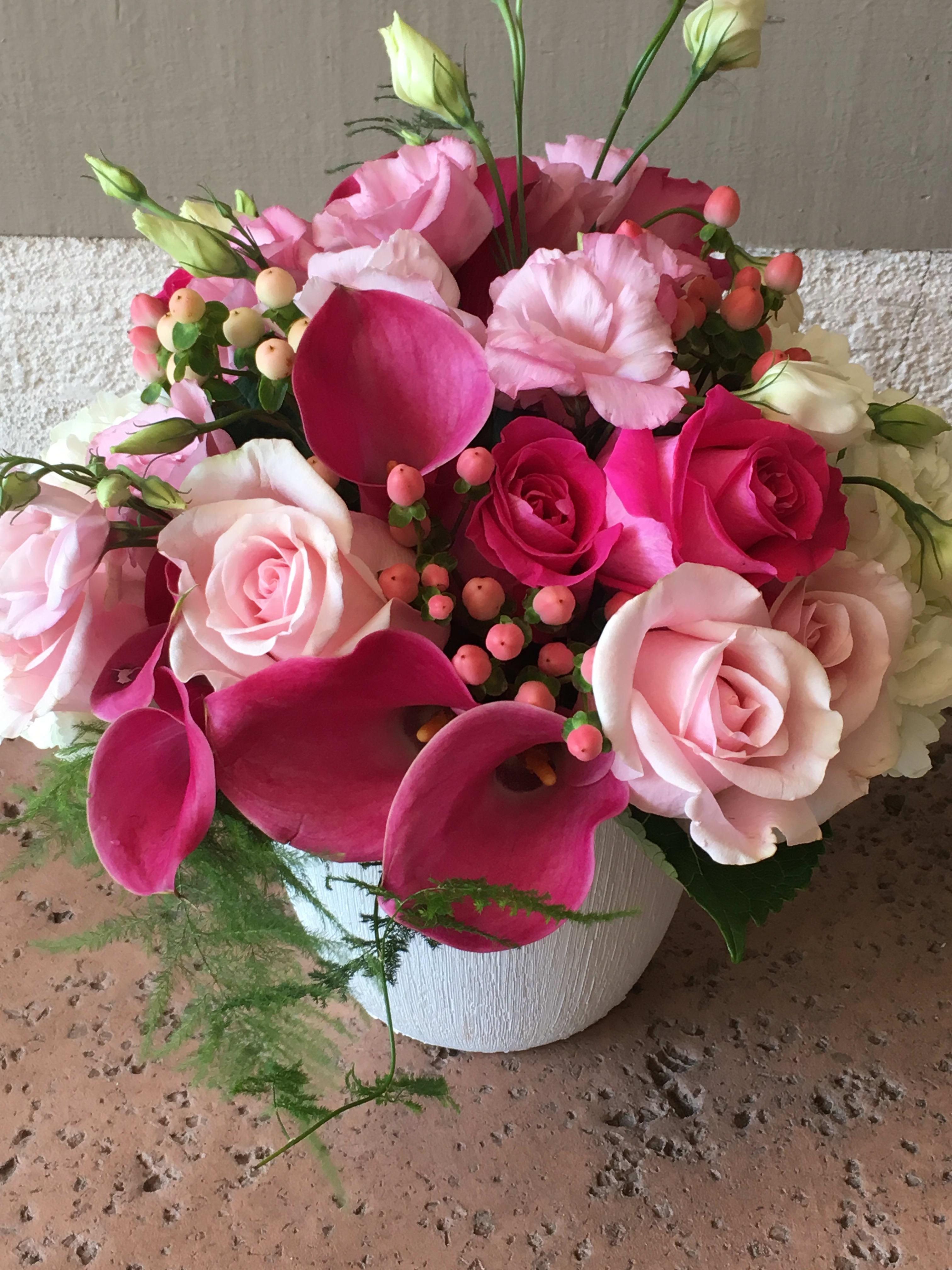 Pink Blooms - A mixture pink lisianthus, roses, coffee beans, calla lilies, with touch of white hydrangeas in a beautiful ceramic white vase.