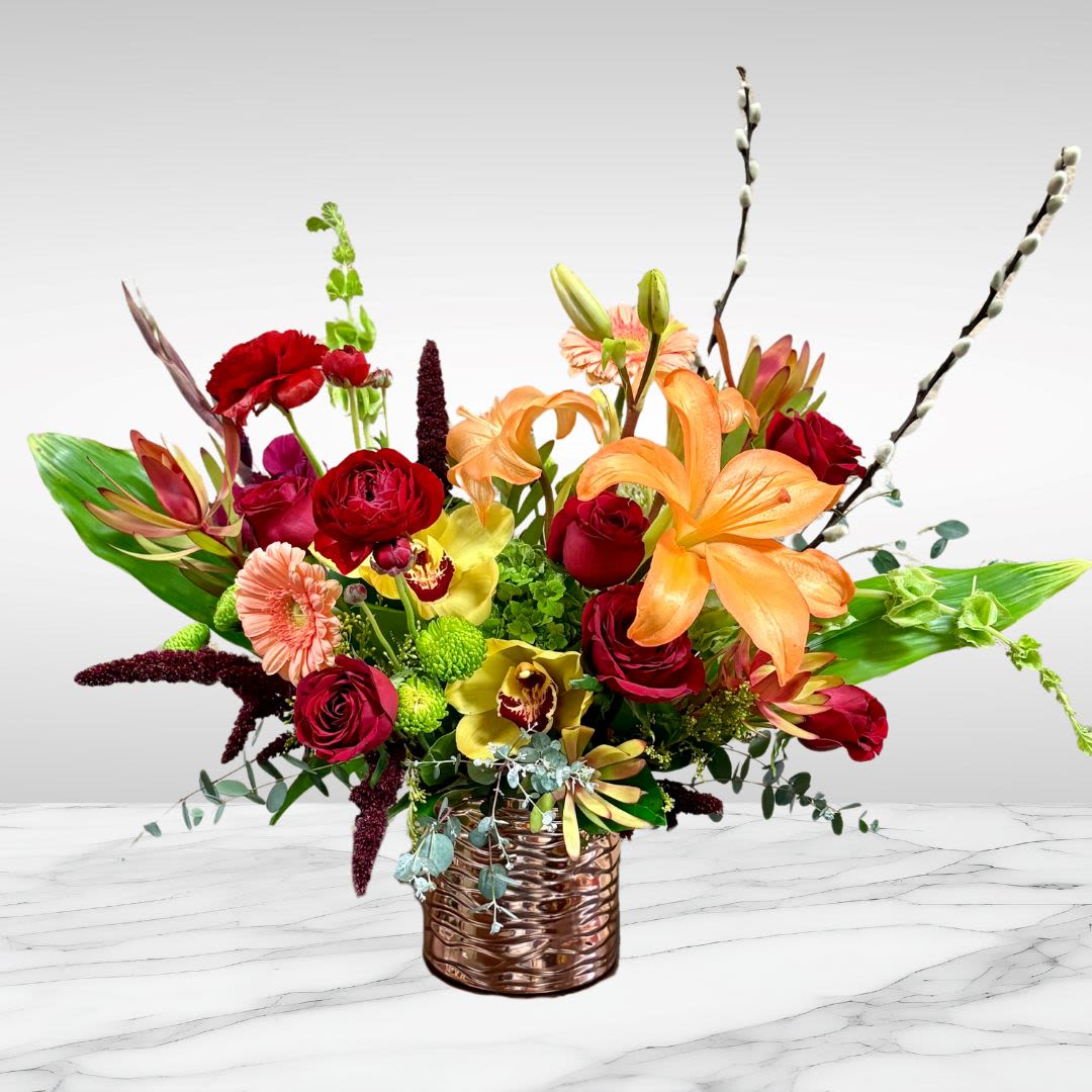 Lush and Lilies - Recipe: Orange stargazers, Ranuculus, Orhcids, Hydrange, Bells of Ireland, Gerbera, Orchids, Safari and more in a rose pink vase. Seasonal: Seasonal Orientation: Front Facing View Photo shown: Standard 