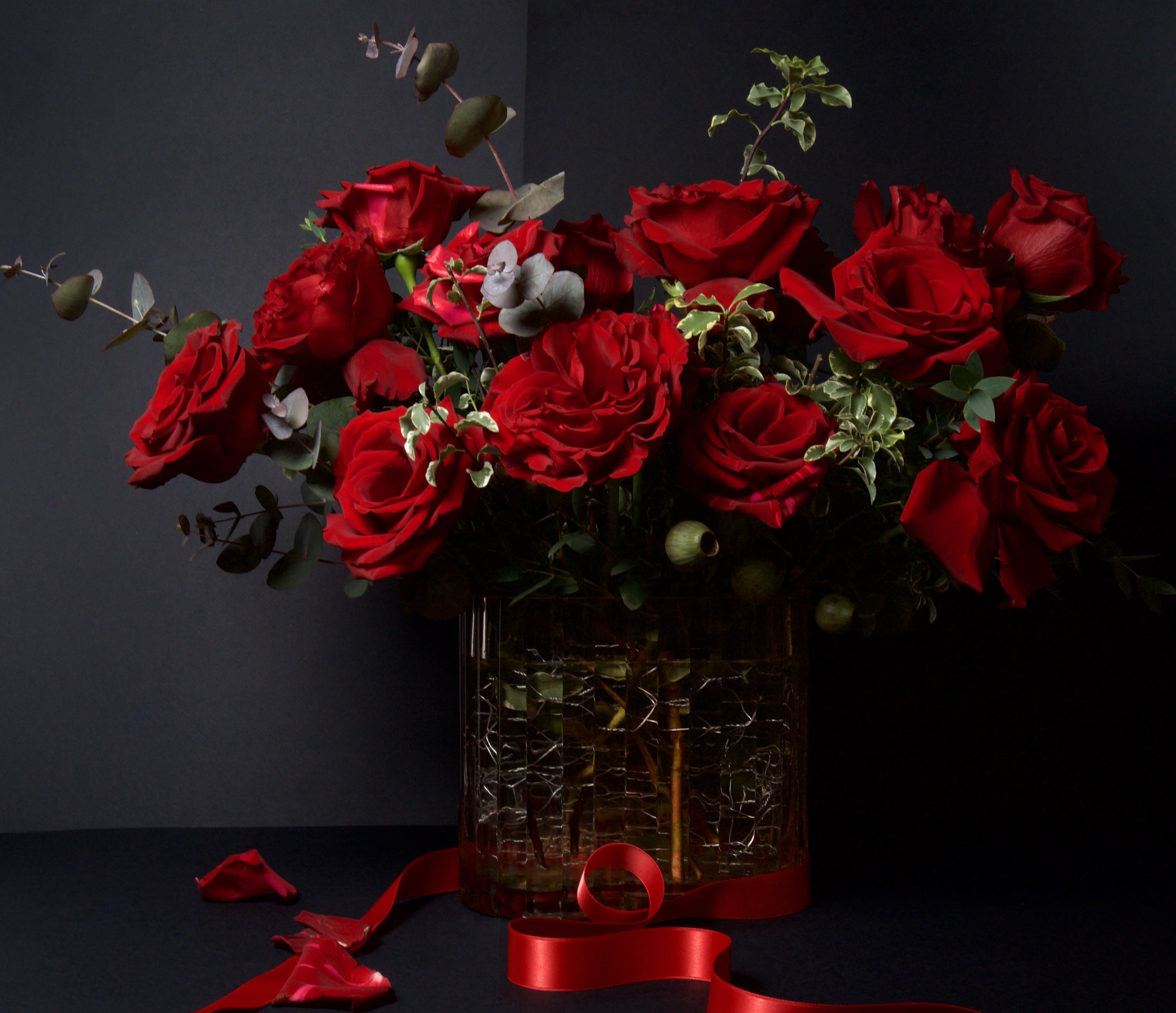 Lexington - 52 - This striking arrangement showcases lush red roses arranged in a full, elegant composition with subtle touches of greenery for depth and texture. The rich red tones create a dramatic and romantic presentation that feels timeless and luxurious.  Roses are the classic symbol of love and devotion, and this arrangement makes a powerful statement without being overstated. Perfect for Valentine’s Day or any meaningful occasion, it is a beautiful way to express love, admiration, and heartfelt emotion.
