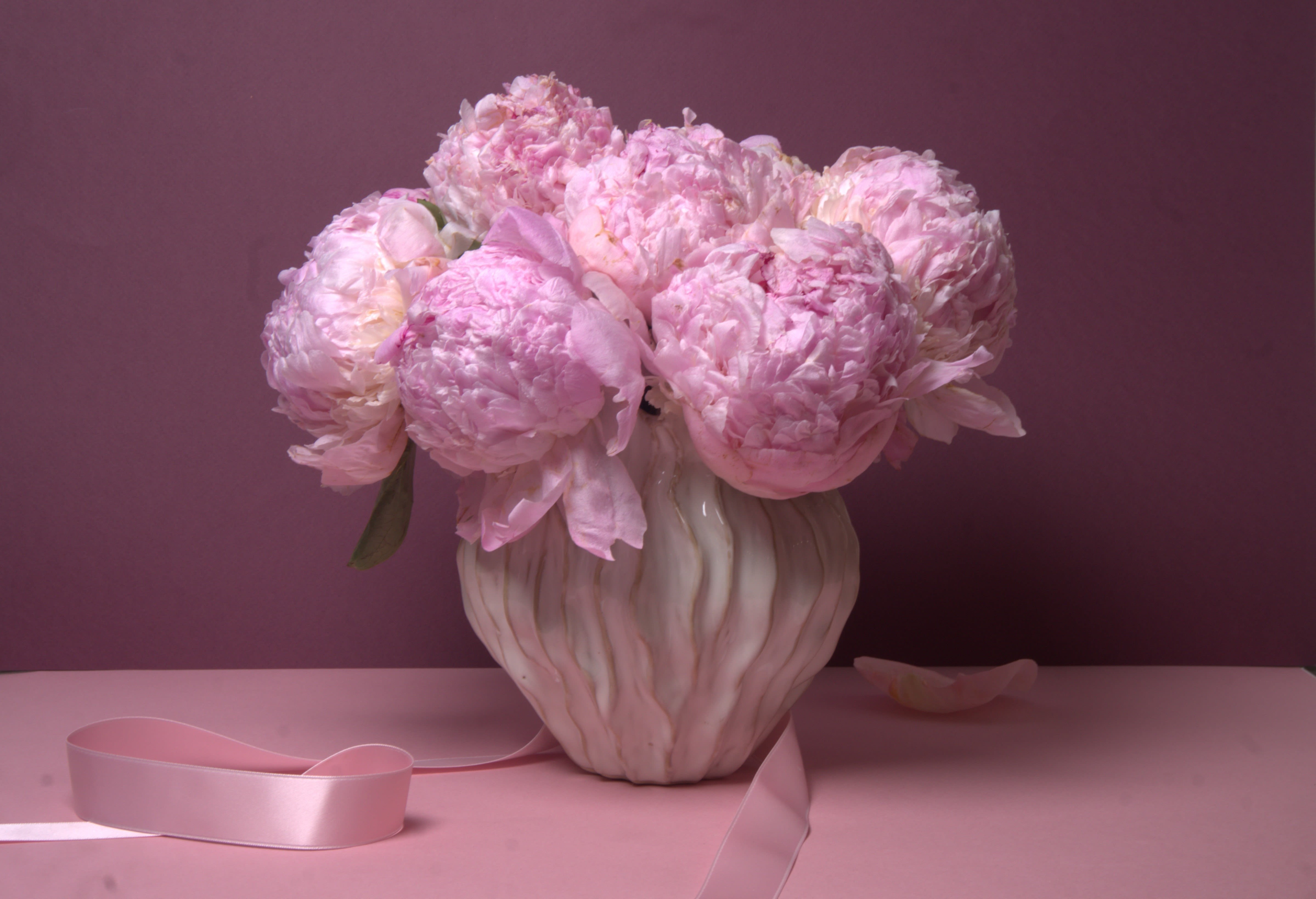 Madison - 73 - A beautiful arrangement featuring full, fragrant pink peonies gathered closely together to create a soft and luxurious display. These lush blossoms are known for their generous petals and romantic presence, making them a favorite for celebrating love, gratitude, and life’s most meaningful moments.  Designed in a classic pavé style, the peonies are arranged low and full, allowing their natural beauty to take center stage. The result is an elegant and timeless composition that feels both comforting and special, perfect for marking an occasion or simply bringing beauty into the home.  This arrangement is available with 10 peonies or 20 peonies, thoughtfully arranged in a decorative ceramic vessel.