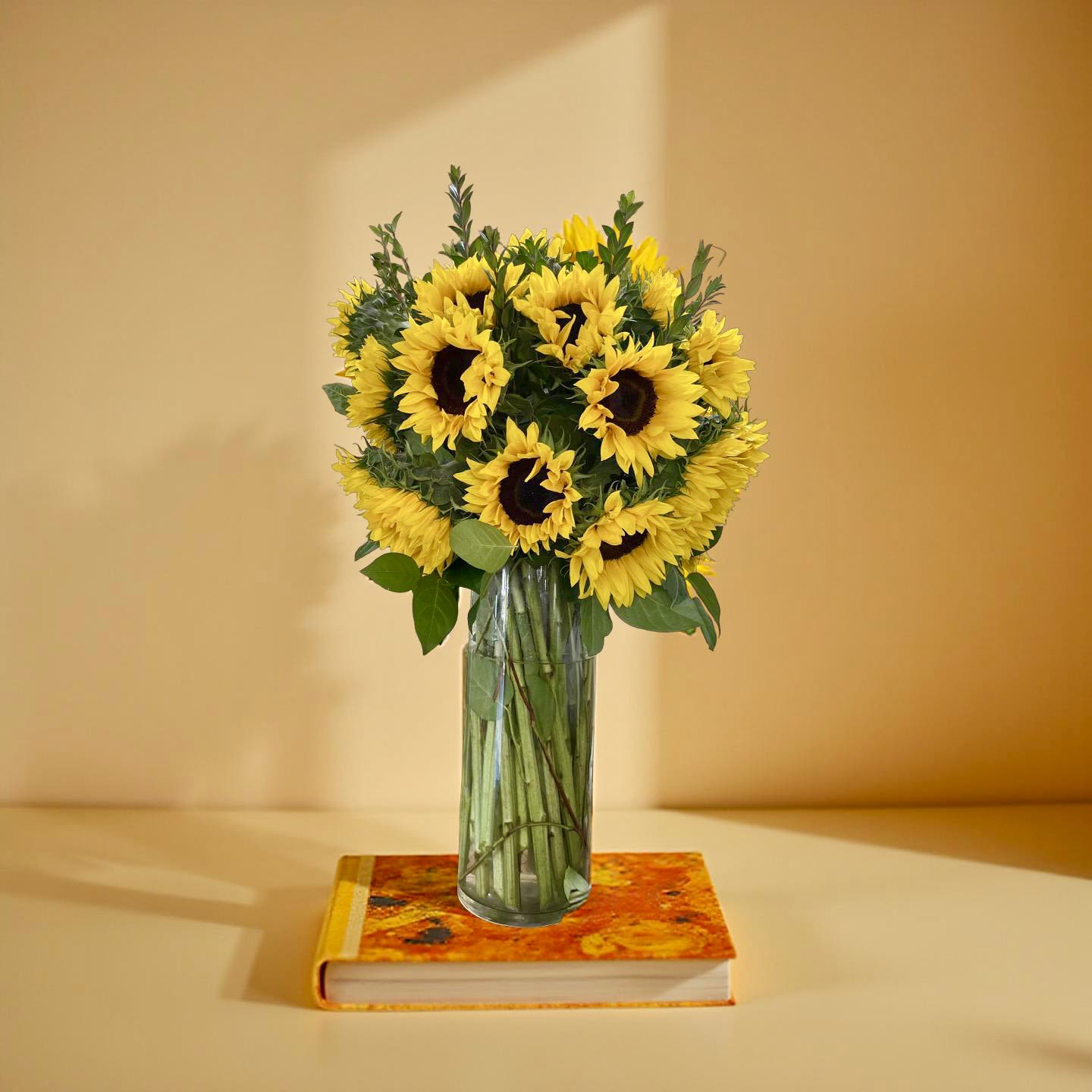 Sunny Day Delights Bouquet - Brighten any room with this stunning Sunny Day Delights bouquet. Bursting with cheerful yellow sunflowers and fresh, crisp greenery, this arrangement captures the essence of a perfect summer day. Presented in a clear glass vase and ready to display, it makes the perfect gift to send a smile to a loved one or to add a touch of sunny happiness to your own home. Each bloom radiates warmth and joy, guaranteeing to lift spirits instantly.This is a Deluxe Product picture. (which is included 30-35 stems Sunflowers)