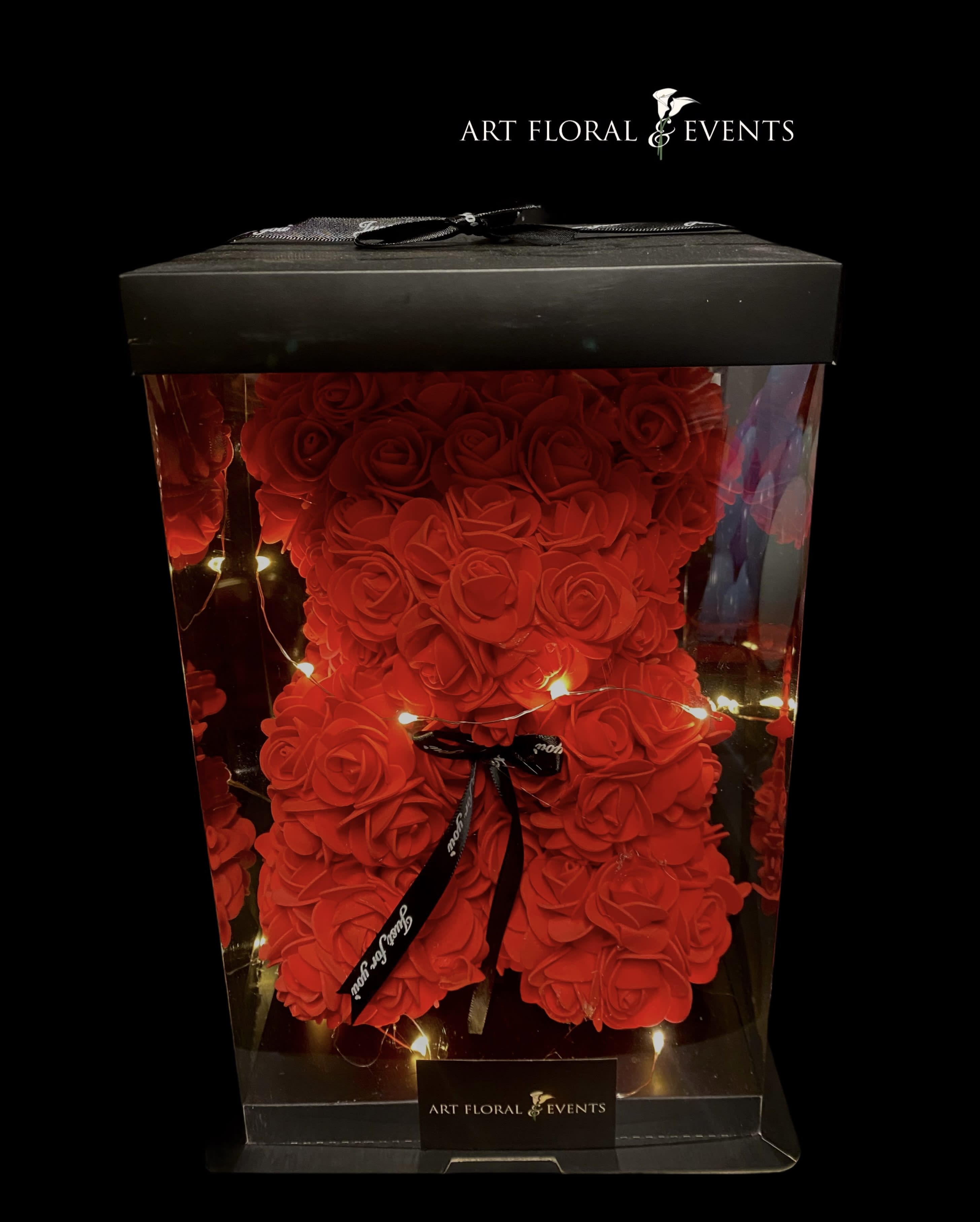 Light Up Rose Bears SMALL - 10 inch 3D Teddy Bear embellished with faux roses, includes light-up fairy lights concealed in a crystal clear black accent box decoratively wrapped with a black ribbon made just for you! AVAILABLE COLORS: PINK, RED, WHITE, PURPLE ***please specify what color you'd like in the florist instructions at checkout***