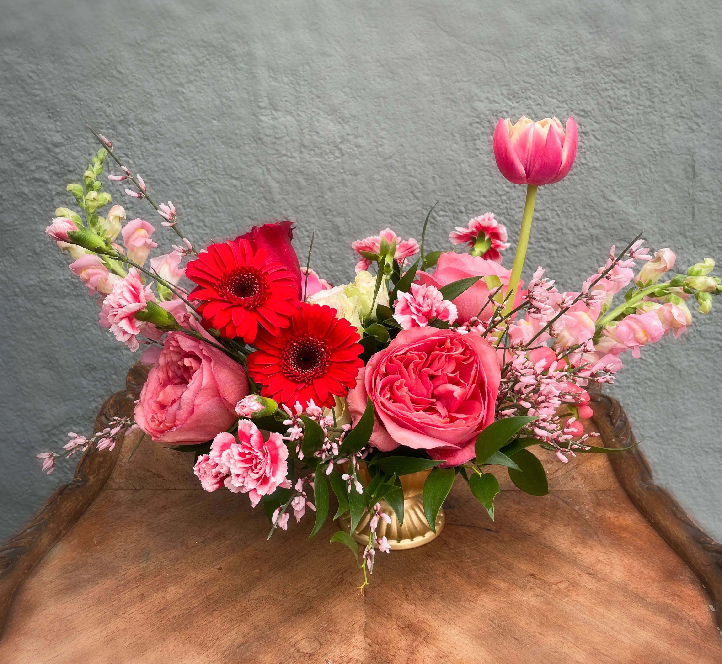 Alice - A petite compote style arrangement in pink and red with a fun expressionistic vibe. Floral varieties and exact composition may vary but overall style and color pallet remains the same. Please note that this is a smaller design appropriate for a coffee table, desk, or 2-4 person table.