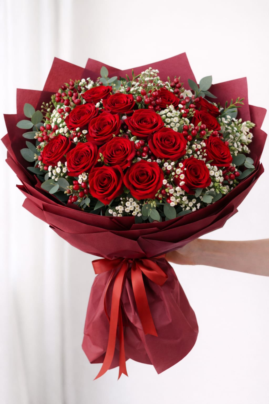 Velvet love  - 2 dozen deep red roses surrounded by soft white blossoms and fresh greens, styled in luxurious burgundy paper for timeless elegance .