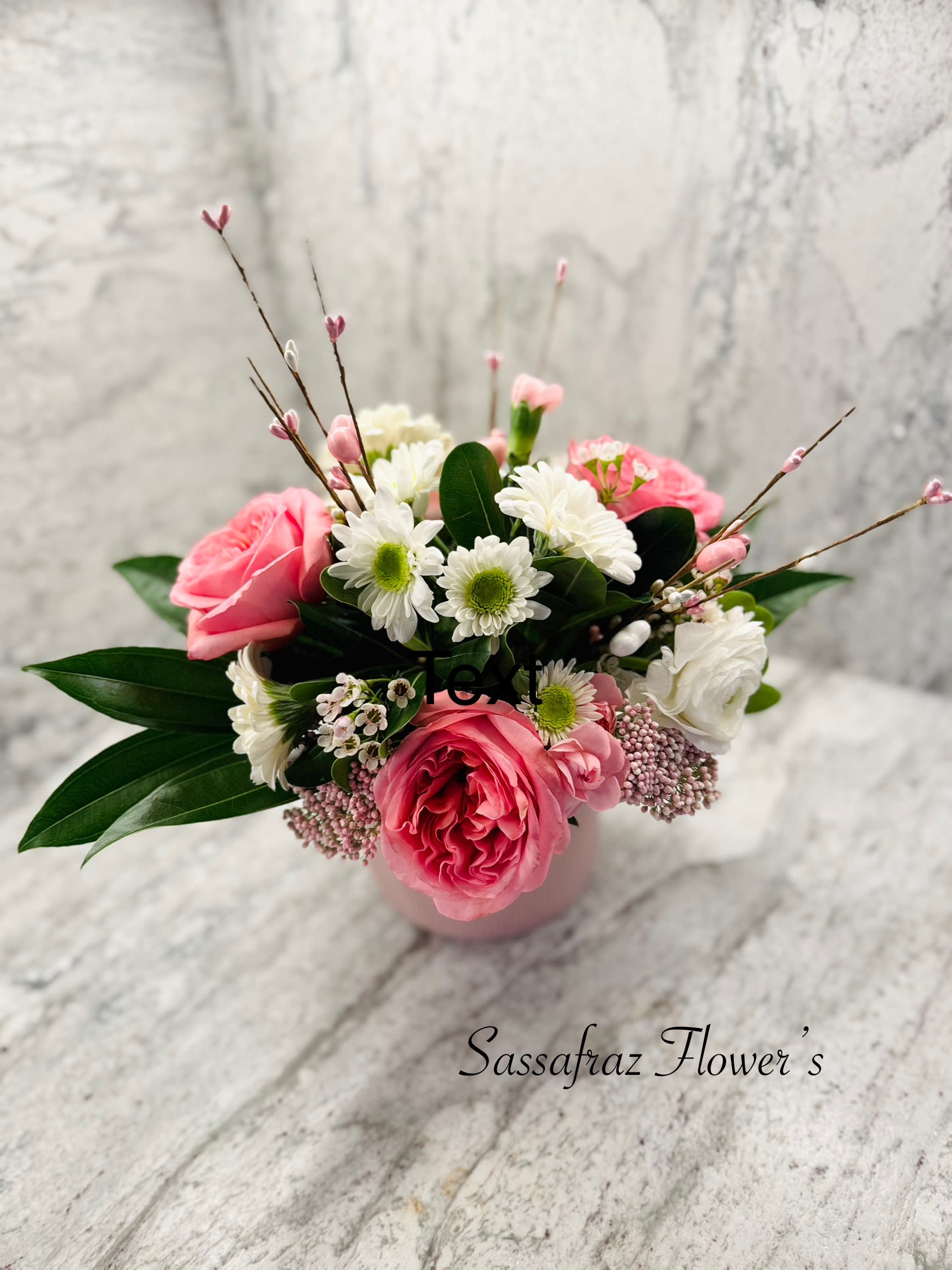 Tickled Pink - Garden heart roses in pink, white Gerber daisies, filled with the sweet aroma of wax flower, ranunculus and spray roses. Show that special someone your thinking of them this Valentines day!