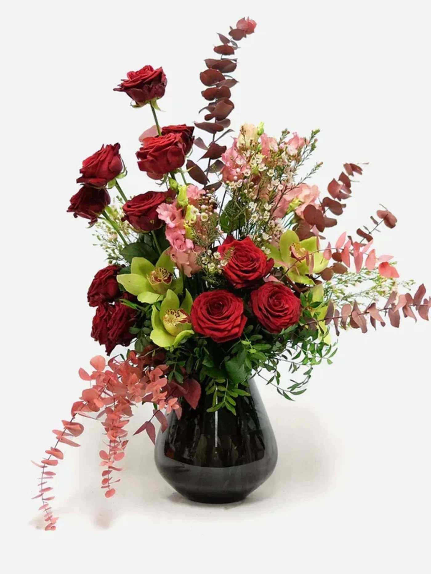 The queen of autumn bouquet - The queen of our autumn bouquets! Capture the play of shadows on a pensive autumn day with this bouquet. The simple but effective combination of orange and red flowers reflects the autumn colours in a beautiful and understated way. Send this colourful autumn bouquet and bring joy to family and friends. Red roses and green Cymbidium Orchid flowers with seasonal foliage stretching in different directions. 