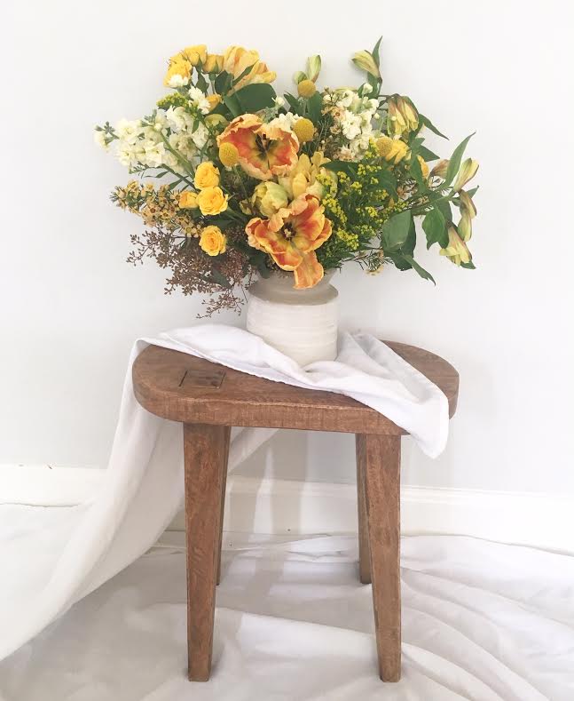 The Beatrice - I love being outside on our screened in porch and this arrangement reminds me of a sunny afternoon brunch. Orange and lemon fill this beautiful pottery vase like a Van Gogh painting. Full of parrot tulips, yellow spray roses, playful billy balls and wild eucalyptus greens, this centerpiece will bring out your inner French Impressionist.  Photo shown is the Deluxe  *** Please NOTE: Do to the Covid-19 shutdowns, flower substitutions will most likely occur but we will strive to make them even more gorgeous than the photos :)