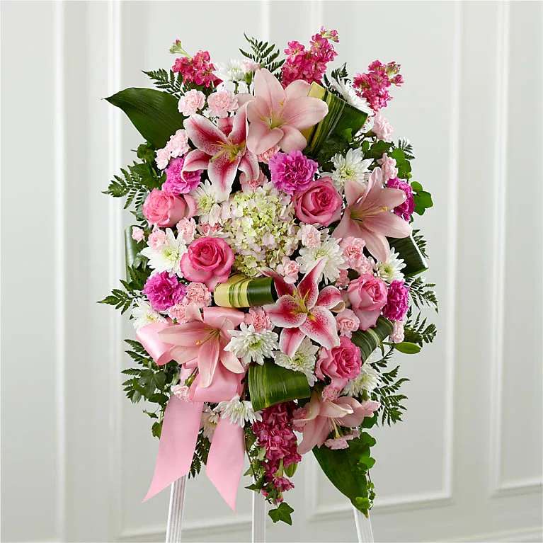 Comforting Standing Spray - Our Comforting Standing Spray combines blushing blooms in a classic standing design to elegantly accent your messages of heartfelt sorrow. Crafted by our talented designers, this grand tribute is a beautiful array of hydrangea, lilies, stock, roses and more. It makes a stunning display at any memorial service for the passing of a loved one.