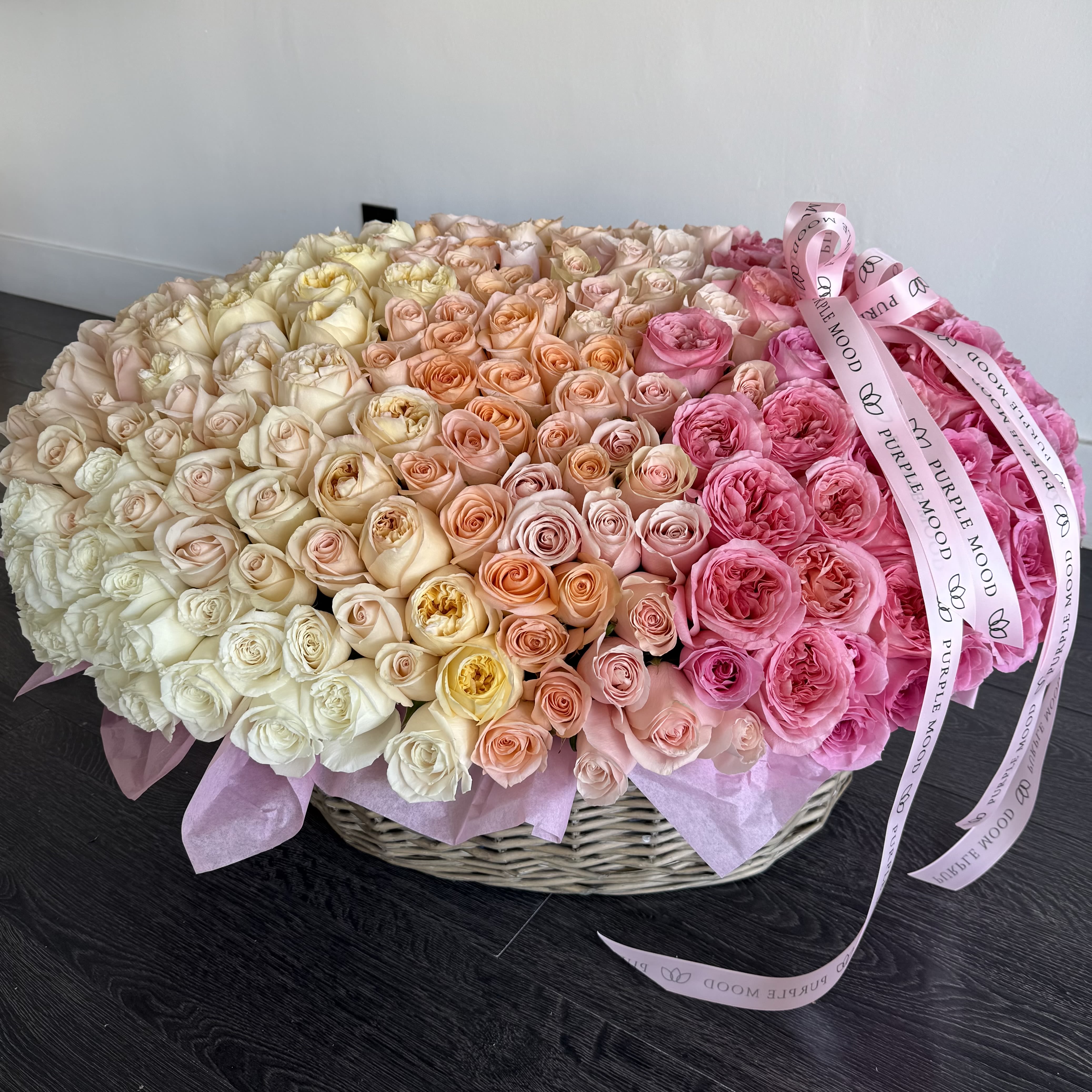 250 Roses Basket - A breathtaking grand arrangement of 250 premium roses hand-designed in an exquisite ombré of ivory, blush, peach and romantic pink.  This extraordinary statement piece is created to celebrate love in every shade — soft, passionate, and everlasting. Designed in our signature Purple Mood basket, this is a once-in-a-lifetime Valentine gift for someone truly unforgettable.