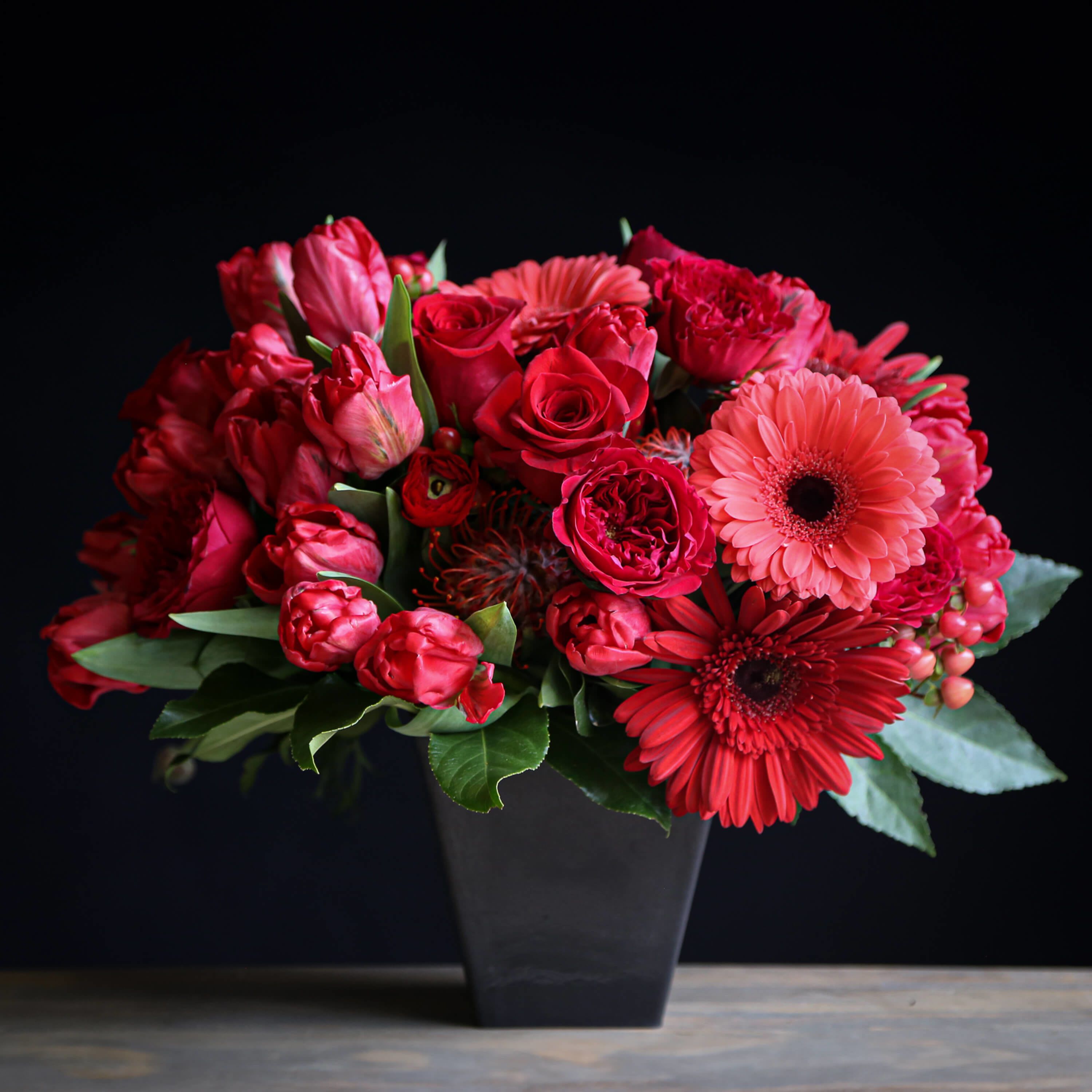 Garnet Glory - A stunning gem. Garnet Glory is a symbol of love and friendship. Flowers like gerber daisy, hypericum, and tulips make this a real stunner.