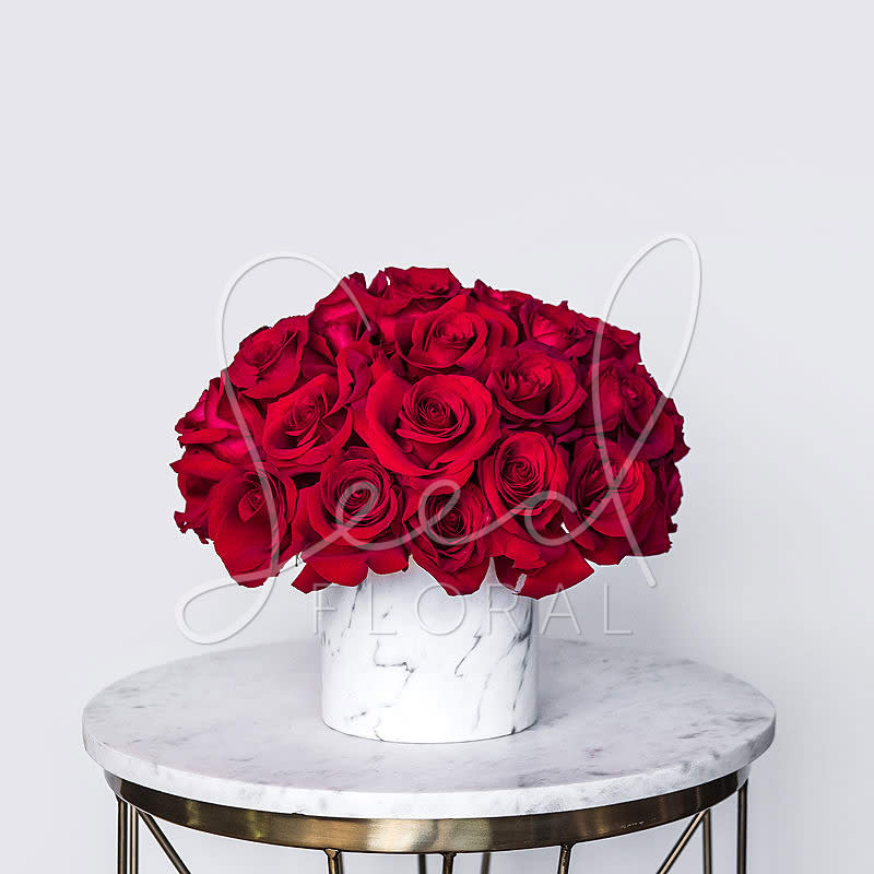 Rose Glam Collection - Vday Red - Make a bold yet graceful statement this Valentine’s Day with Rose Glam, a luxurious arrangement of 30 stems of premium red roses beautifully styled in a sleek white ceramic vase. This striking monochromatic design showcases the timeless elegance of red roses — the ultimate symbol of love and romance.  Whether you're celebrating a long-time love or planning a grand romantic gesture, Rose Glam is the perfect way to say “I love you” with sophistication and style. Its clean, modern presentation makes it a showstopping centerpiece for Valentine’s Day and beyond.