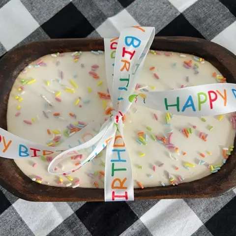 Dough Bowl Soy Candle - "Happy Birthday" - 100% all-natural American farm grown soy wax infused with cake fragrance oil and hand-poured into hand-carved wood dough bowl with 3 cotton lead-free wicks then accented with rainbow sprinkles and satin happy birthday ribbon. 