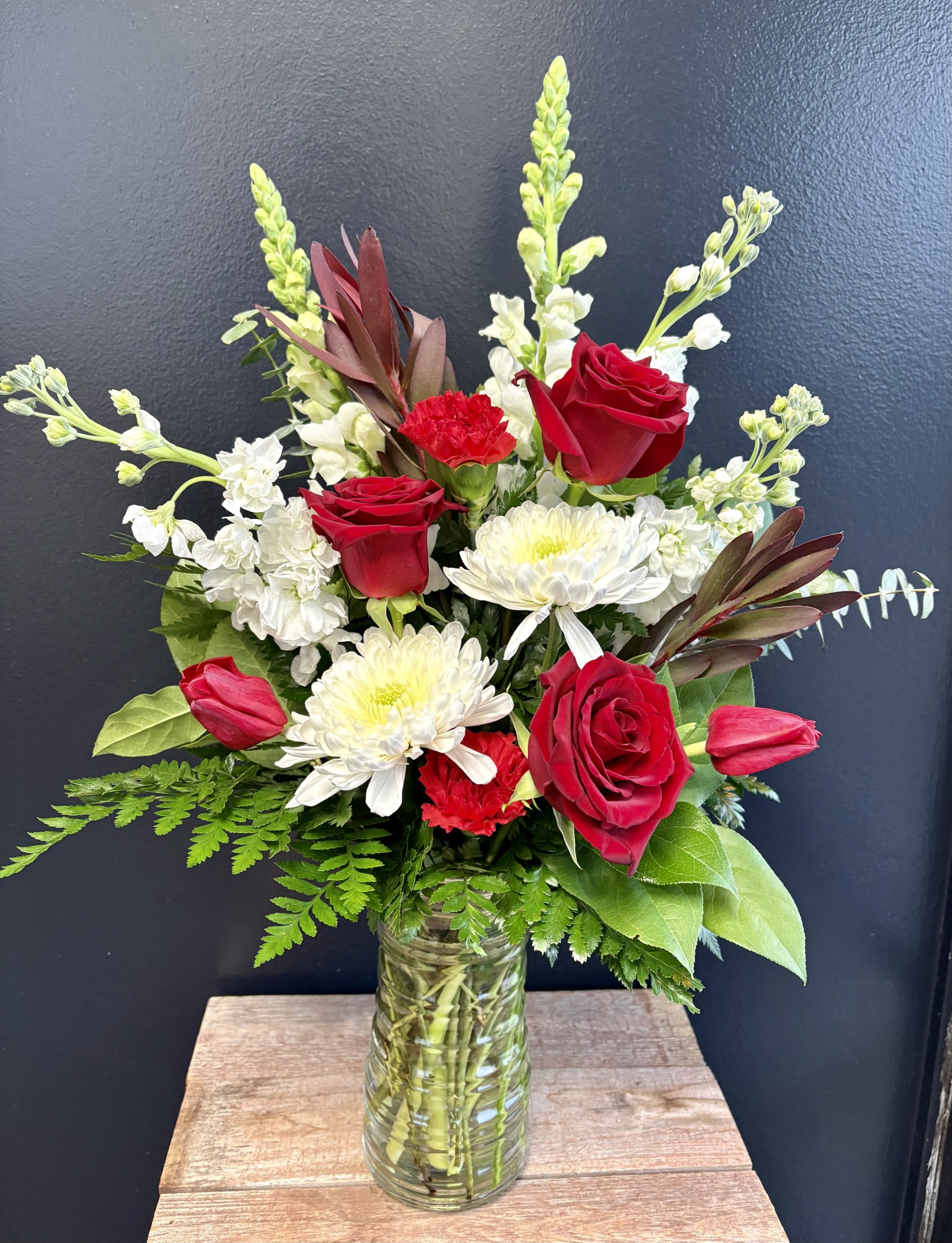 Love Shack  - A striking blend of elegance and charm, this red and white floral arrangement brings timeless beauty to any space. Lush red blooms add depth and passion, while crisp white flowers introduce balance and sophistication. Thoughtfully accented with fresh greenery, the design feels both vibrant and refined.