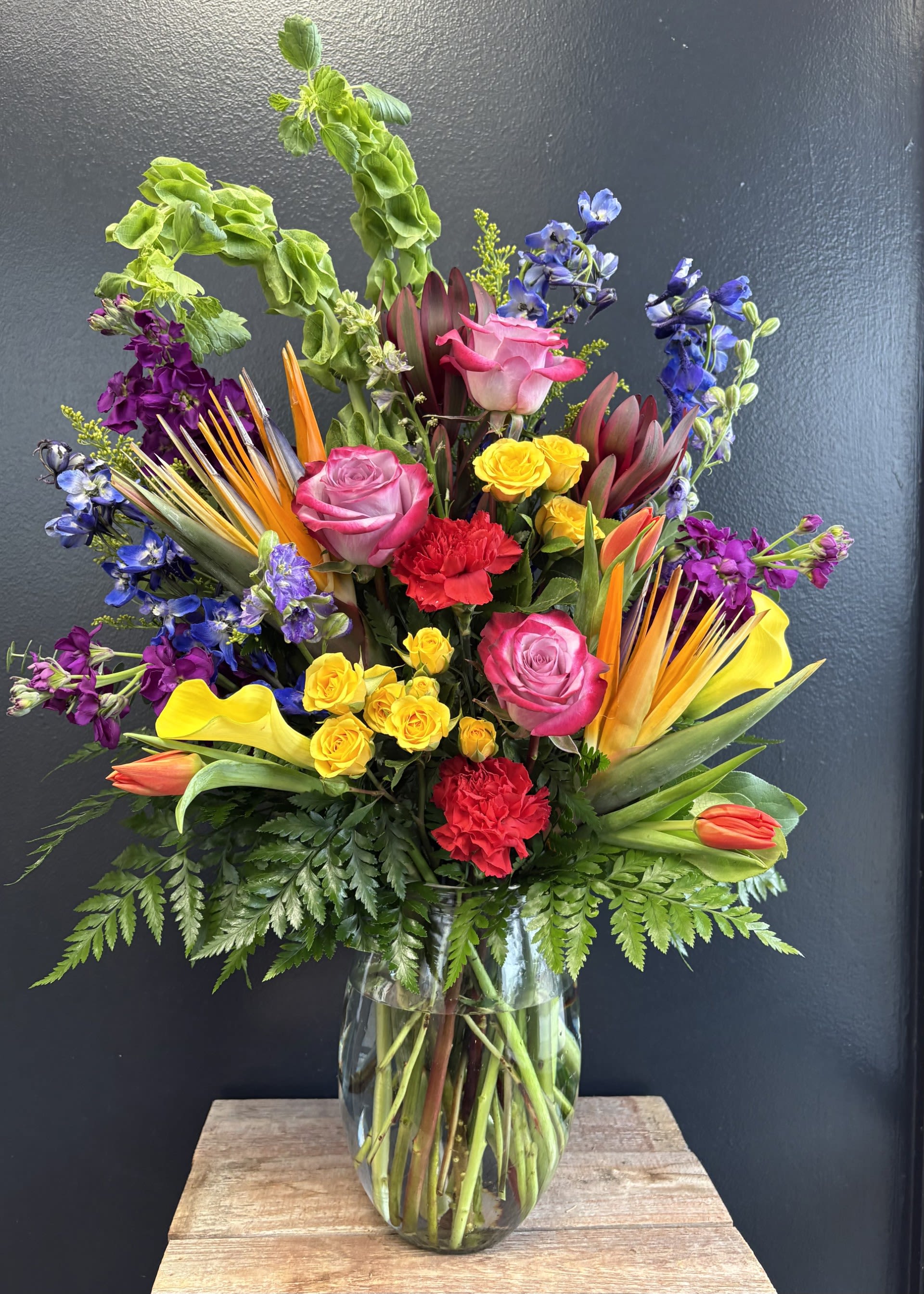 All of Me (Loves all of you)  - Escape to an island paradise with this vibrant tropical bouquet, designed to bring bold color and exotic flair into any space. Striking Birds of Paradise take center stage with their sculptural shape and fiery orange and blue tones, instantly creating a dramatic, sun‑soaked focal point.