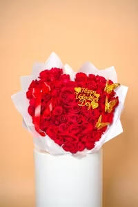 All My Heart Bouquet - A breathtaking heart-shaped arrangement crafted from luxurious red roses, symbolizing deep love and passion. Accented with delicate golden butterflies, a satin red ribbon, and a shimmering Happy Valentine’s Day detail, this design radiates romance and elegance. Wrapped in soft white layers and beautifully presented,  is the perfect statement piece to celebrate Valentine’s Day, anniversaries, or any moment meant to say “I love you” in the most unforgettable way.