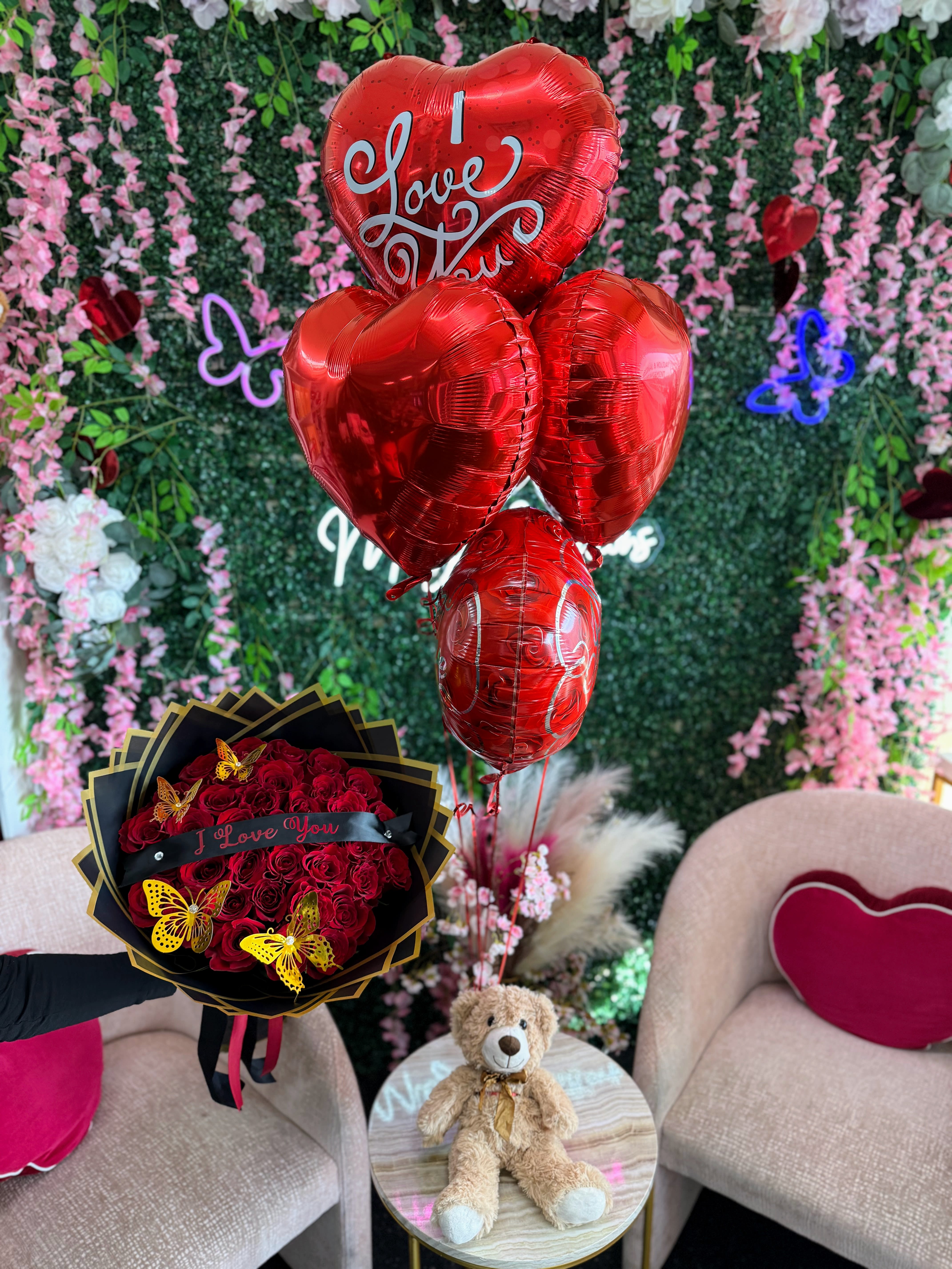 Say I Love You Bundle - Make a bold romantic statement with our Say I Love You Bundle. This unforgettable gift includes a stunning wrapped bouquet of fresh red roses adorned with delicate butterflies, a charming “I Love You” banner, an adorable teddy bear, and a bundle of 5 red heart-shaped helium balloons. Perfect for anniversaries, Valentine’s Day, proposals, or simply to remind someone how deeply they are loved—this bundle delivers romance from every angle. STANDARD 24 ROSES DELUXE 36 ROSES PREMIUM 50 ROSES