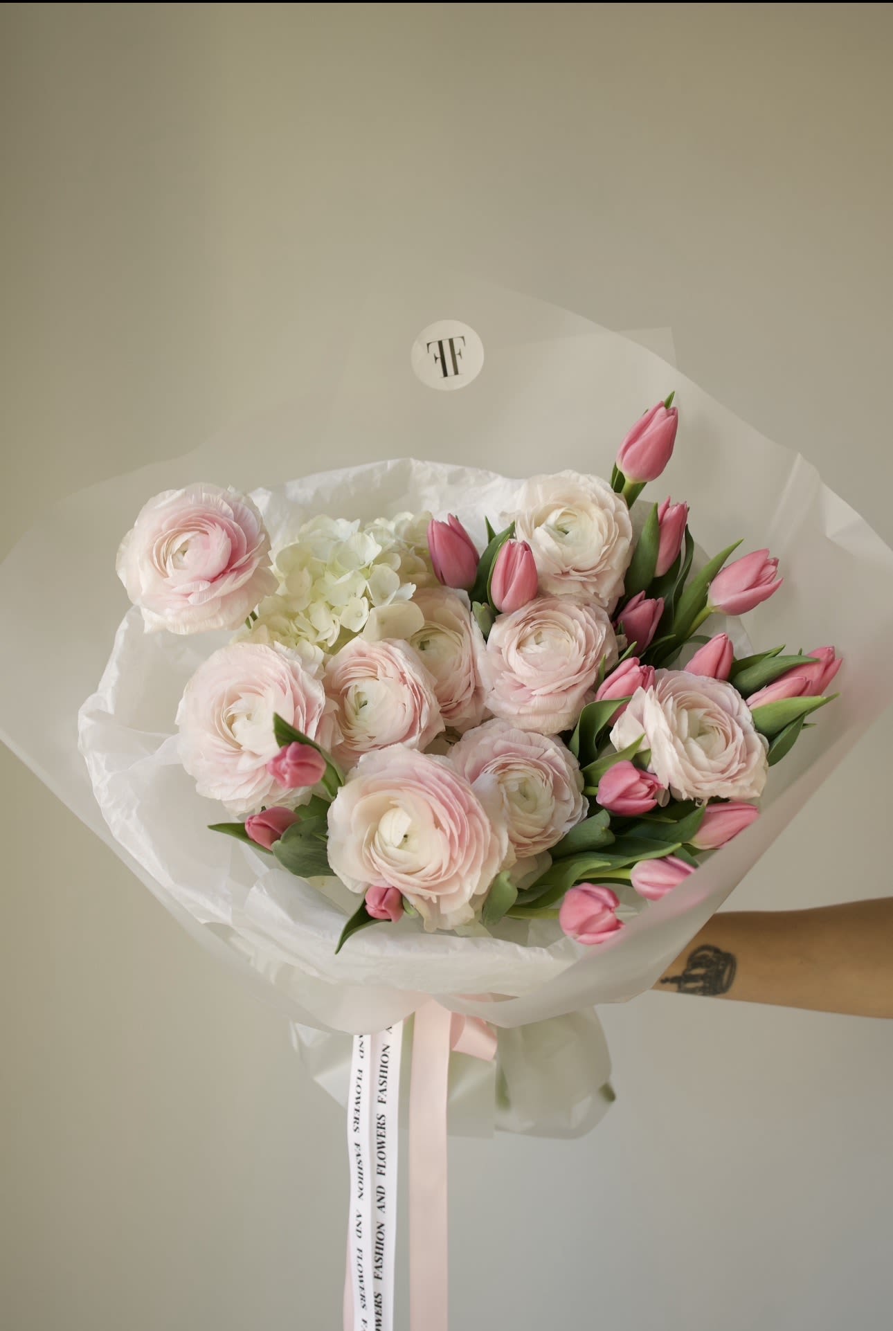 Pink Silence - A delicate composition of blush ranunculus and soft pink tulips, designed to feel light, romantic, and effortlessly elegant. Layered petals and fresh spring textures create a refined bouquet with a modern, airy silhouette.  Perfect for Valentine’s Day, anniversaries, birthdays, or thoughtful luxury gifting. This arrangement speaks softly yet beautifully — a timeless expression of care and affection.