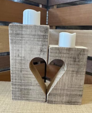 2-piece Candle Set with Heart in middle - This two-piece wooden candle set features offset sizes with a heart when set beside each other.  Each piece is carefully crafted, making every piece truly one of a kind. Approximate size 7" x 3 3/4", 5.5" x 3 1/4"; total width 6.5"