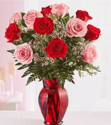 Shades of Pink and Red - Premium Long Stem Roses - Product ID: 91457  She'll be blushing for sure when our beautiful bouquet of pink and red long-stem roses arrives! Hand-gathered by our expert florists in a rich red vase, we can't think of a more colorful way to express yourself to someone very special. This gorgeous bouquet of premium long-stem pink and red roses is accented by fresh waxflower and salal, and artfully arranged by our expert florists. Premium Arrangement has 24 roses, Deluxe has 18 stems, and Standard has 12 stems. Our florists select the freshest flowers available, so colors and varieties may vary.