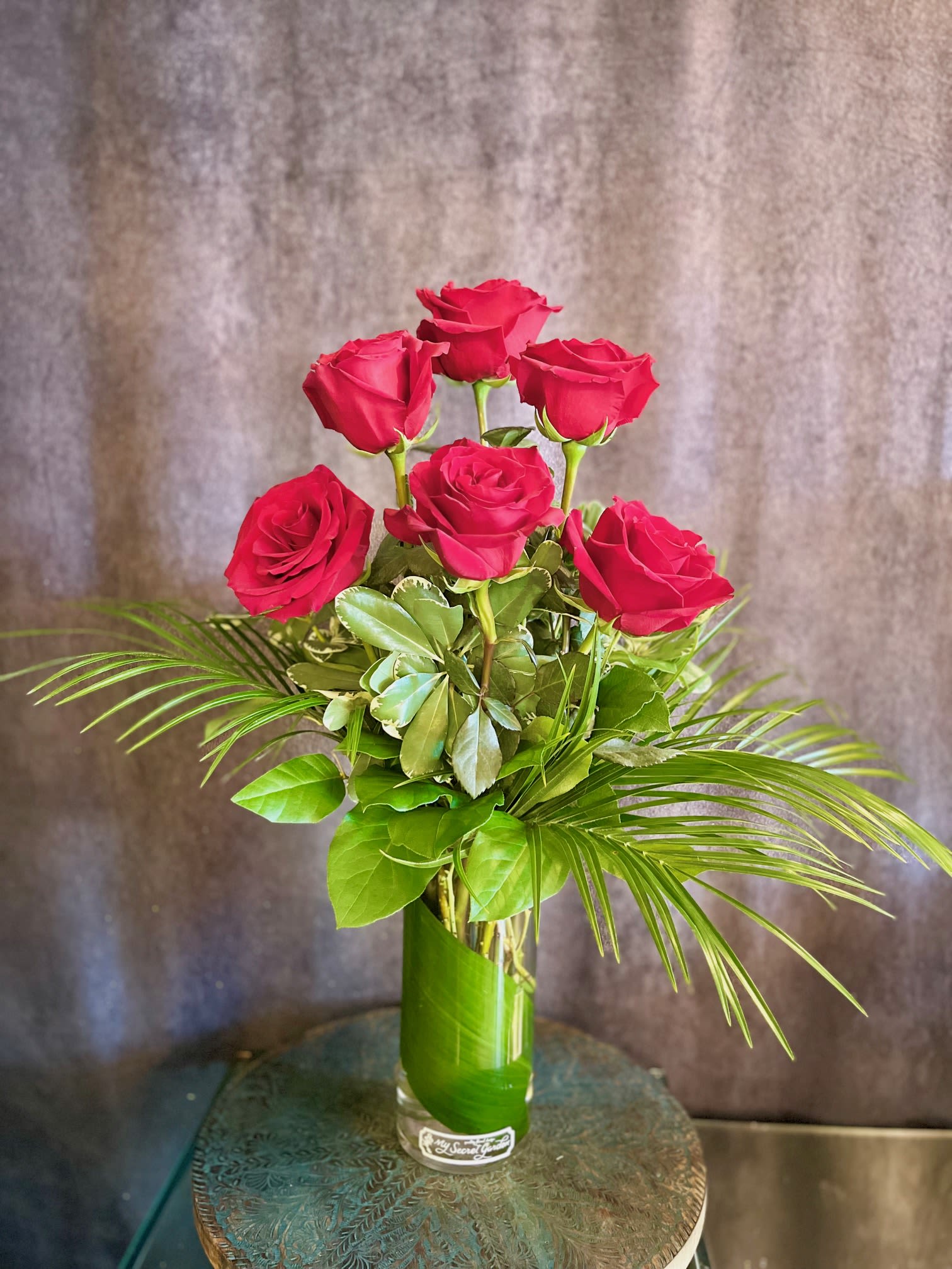 Half Dozen Valentines Roses- Colors: Red, Cream, Vibrant Yellow, Orange, Light Pink, Hot Pink, Purple, Peach - Give the gift of love with our featured Half Dozen Roses.  Colors- including a Half Dozen Roses in the color of your choice! Designed in a clear cylinder glass vase with tropical foliage. Stands approximately 24 inches tall. ***Please write the color or roses that you prefer in the special instructions section of your order. Colors available: Red, Cream, Vibrant Yellow, Orange, Light Pink, Hot Pink, Purple, Peach or Mixed colors***