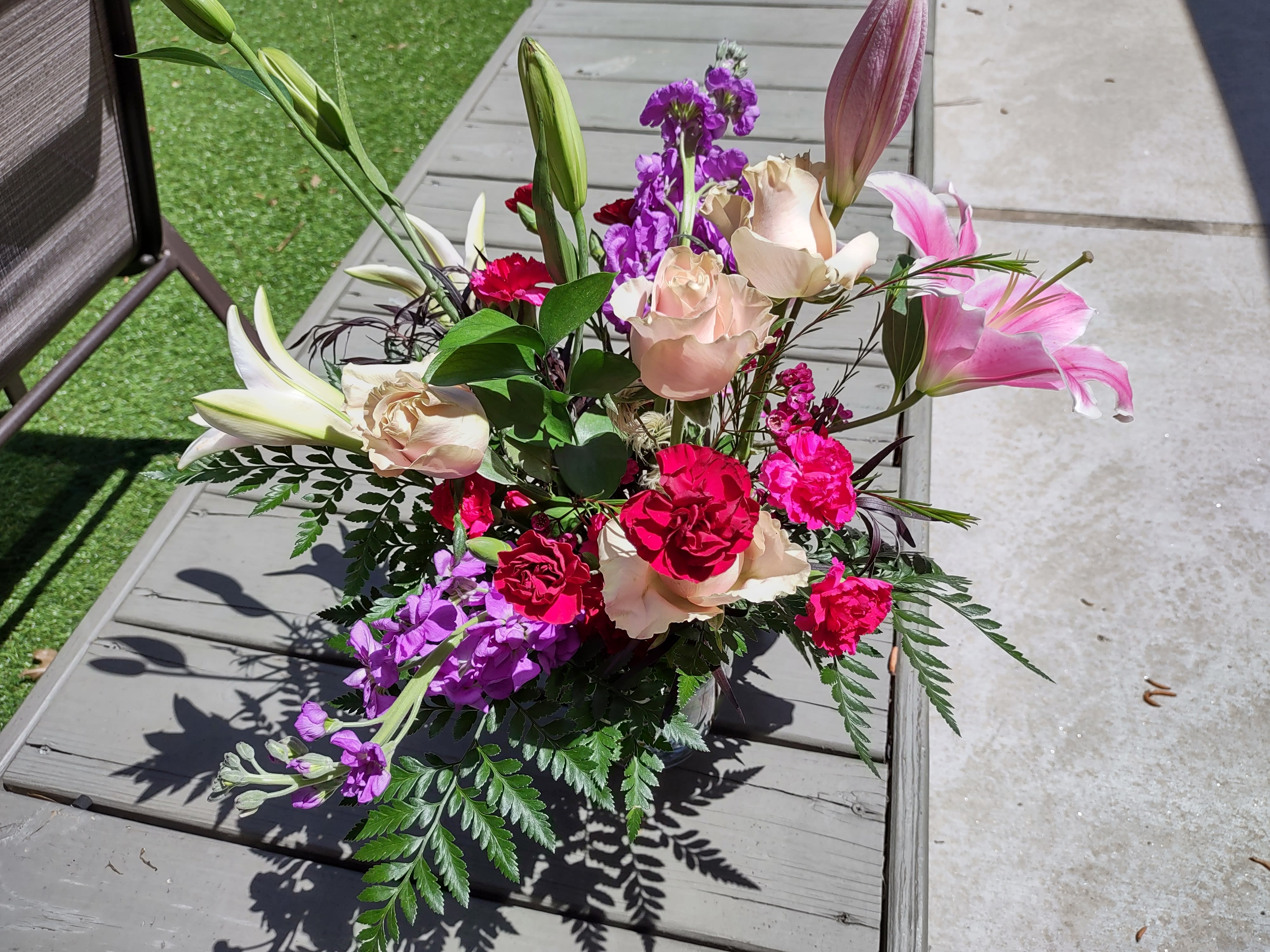 South Fulton Stunna - Named for the blackest city in America, South Fulton Georgia.A stunning arrangement of Stargazer Lilies, Red roses, purple Lisanthius and statice, filler and mixed greenery in a tall clear vase. Can't stop, won't stop Stuntin'