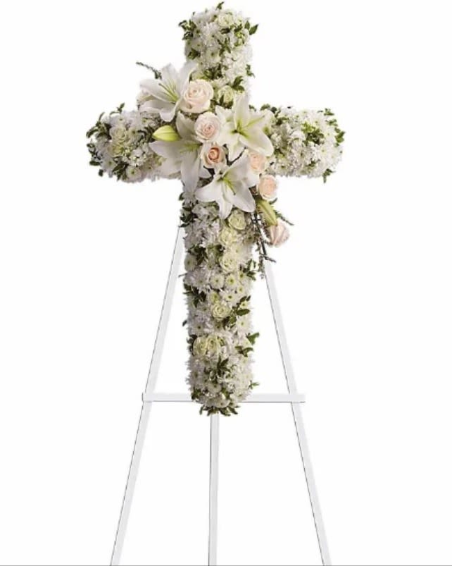 Divine Light - Your message of hope for eternal serenity is delivered ever so elegantly in this graceful cross. Your sincerity will be acknowledged by all who are present. Crème roses, white spray roses, oriental lilies, stock, leptosporum, cushion and button spray chrysanthemums create a cross that is a beautiful way to honor a loved one.Approximately 22 1/2" W x 36" H