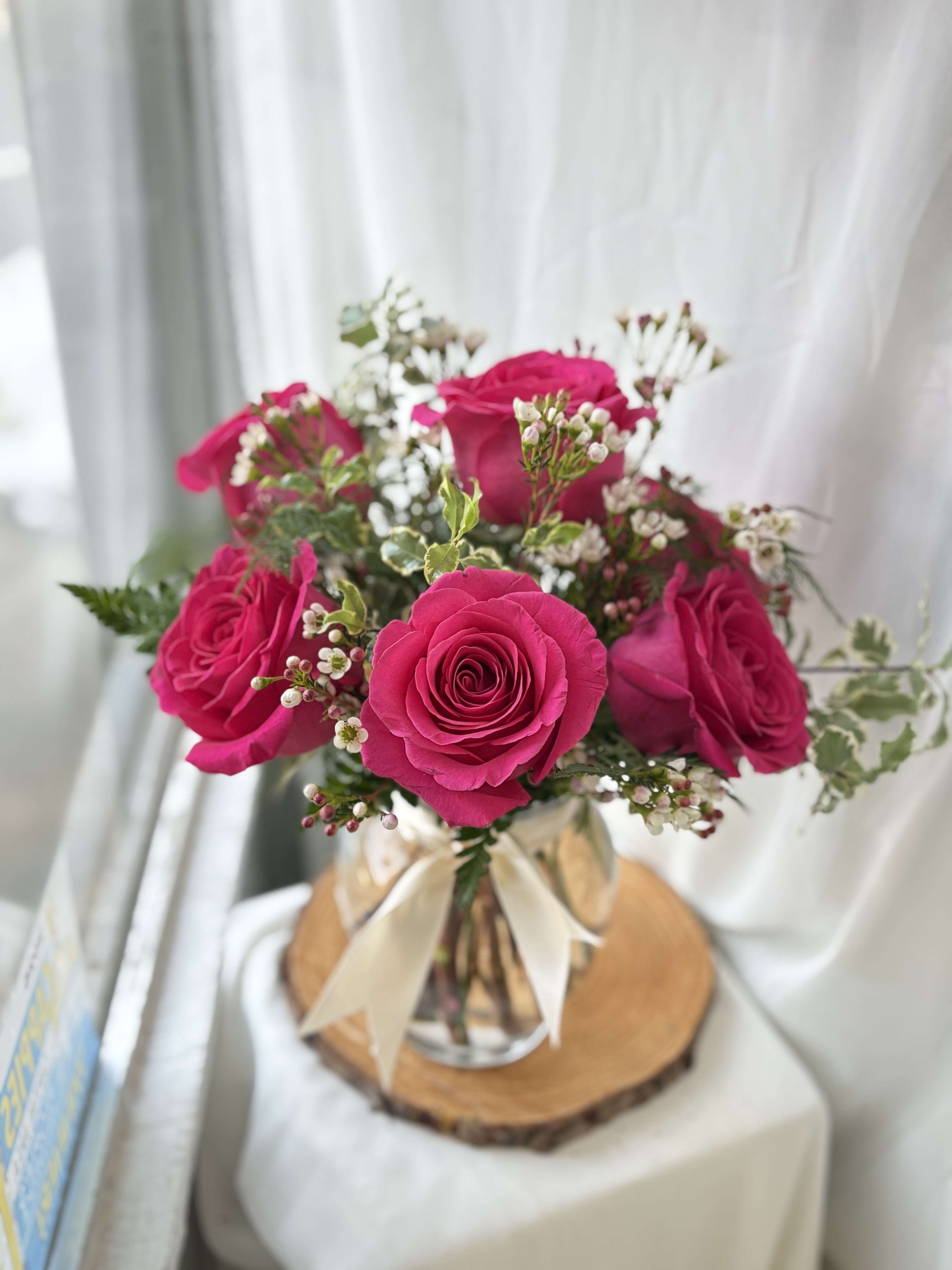 1/2 Dozen Roses Arranged - 1/2 Dozen of our freshest Roses with white filler flower and greenery arranged in a clear vase! The Roses pictured are a shade of pink, we will be offering RED Roses this holiday! We cannot guarantee the same colors and varieties of flowers pictured, but it will give the same style and feel!