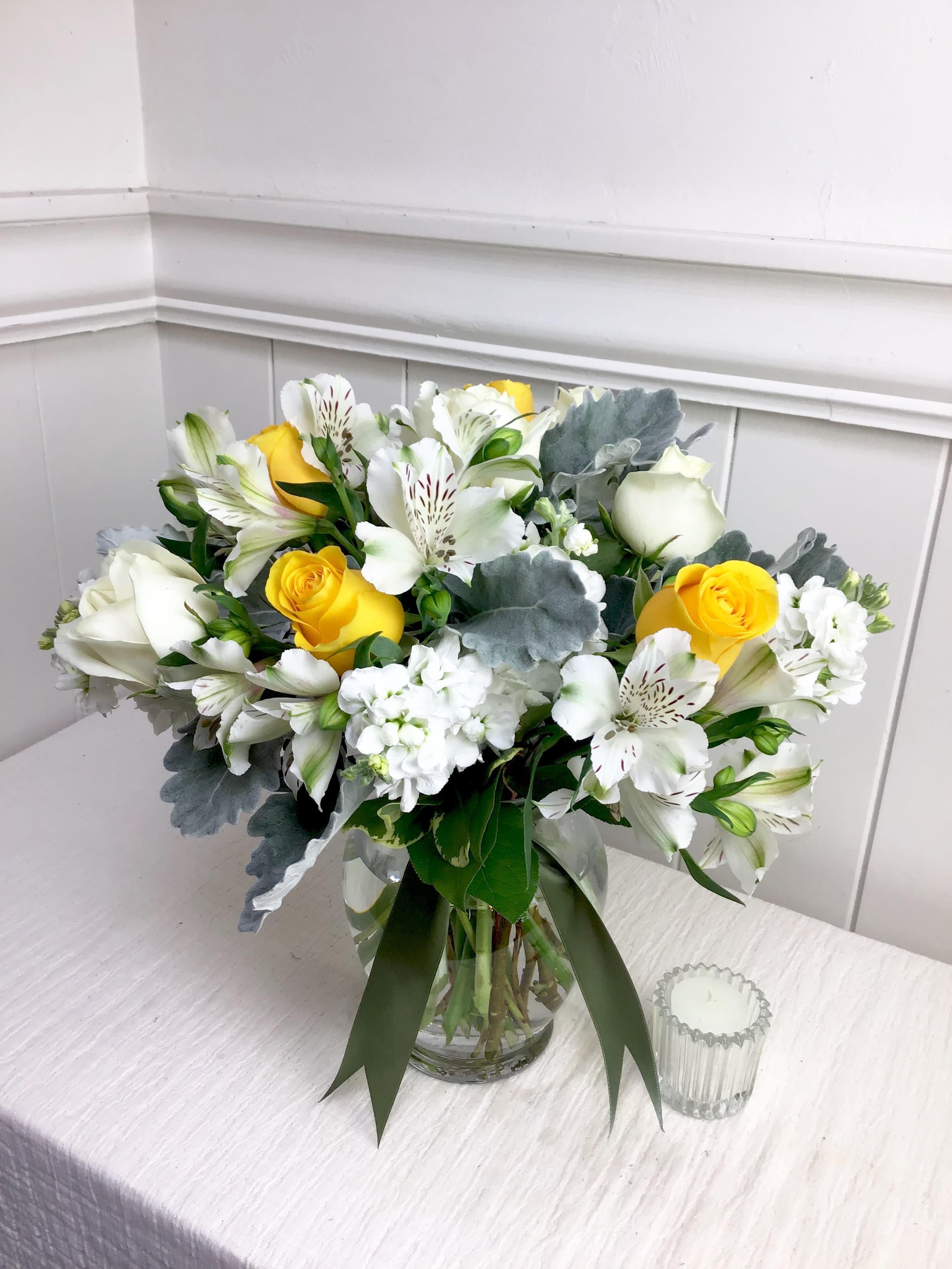 Artisan - Soft white stock and gorgeous yellow roses, resting on silver dusty miller. An elegant arrangement for any occasion.   Upgrade for a larger arrangement, including more roses and extra premium flowers. 