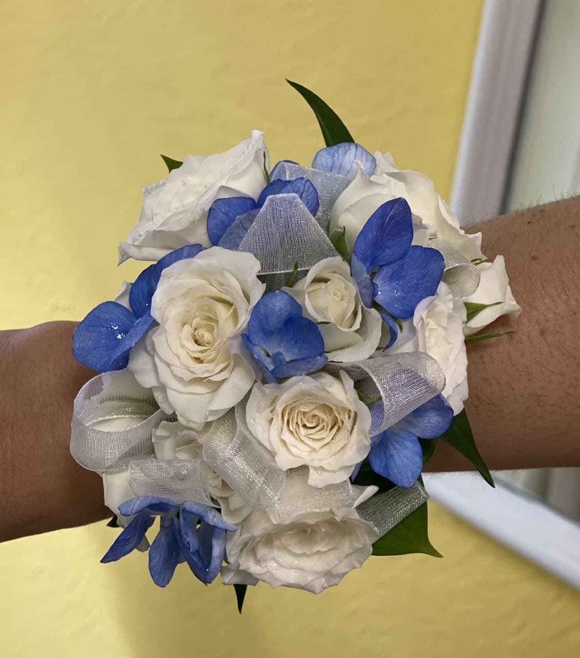 White and blue corsage - A classic rose wrist corsage combined with blue hydrangea or blue delphinium. Perfect for prom, homecoming, wedding, or any other formal event.