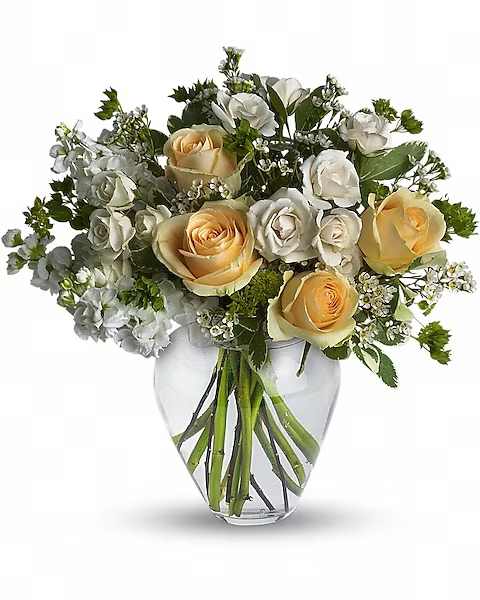Celestial Love - Peaceful and pure. This pretty arrangement of white and light colors will let anyone know they are in your thoughts. Fresh flowers such as peach roses, crème spray roses, white stock, waxflower and more are gathered in a beautiful clear vase.  Orientation : All-Around All prices in USD ($) Due to an increase in the cost of roses, some product prices may be impacted during the Valentine’s delivery period.