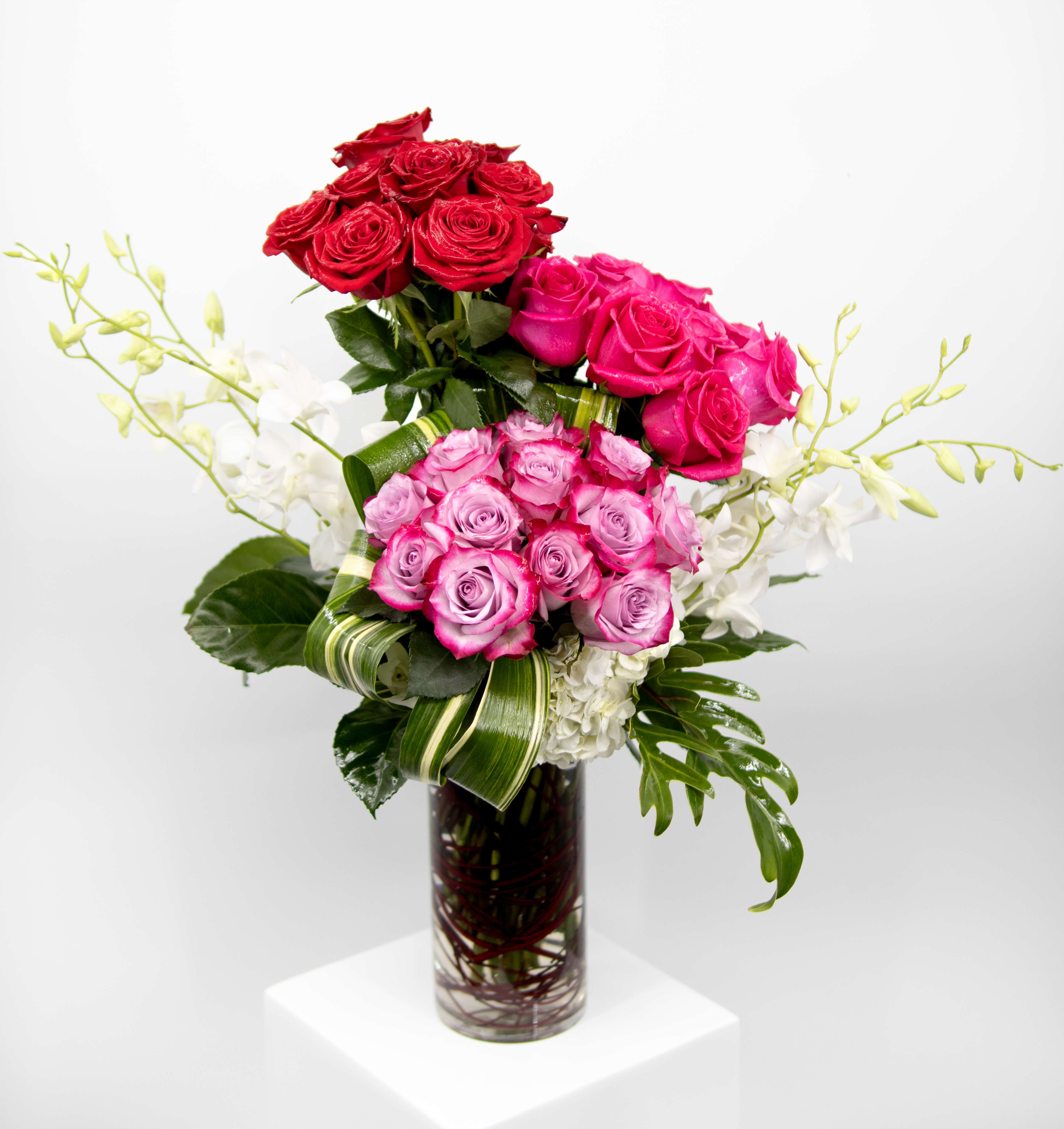 Audrey  - Introducing Audrey, a timeless floral arrangement. Choose from 3, 4, or 5 dozen roses, meticulously styled in a classic traditional arrangement, accompanied by lush greenery and handpicked orchid stems. Audrey captures the essence of refined beauty, making a statement in any setting. Whether it's a grand celebration or a heartfelt expression of love, this arrangement is designed to leave a lasting impression. 