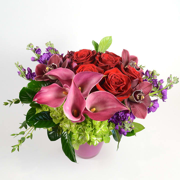 Captain Romance  - Our stunning Captain Romance arrangement is created with a dozen red roses, calla lilies, hydrangea, and cymbidium orchids and accented with eucalyptus. 